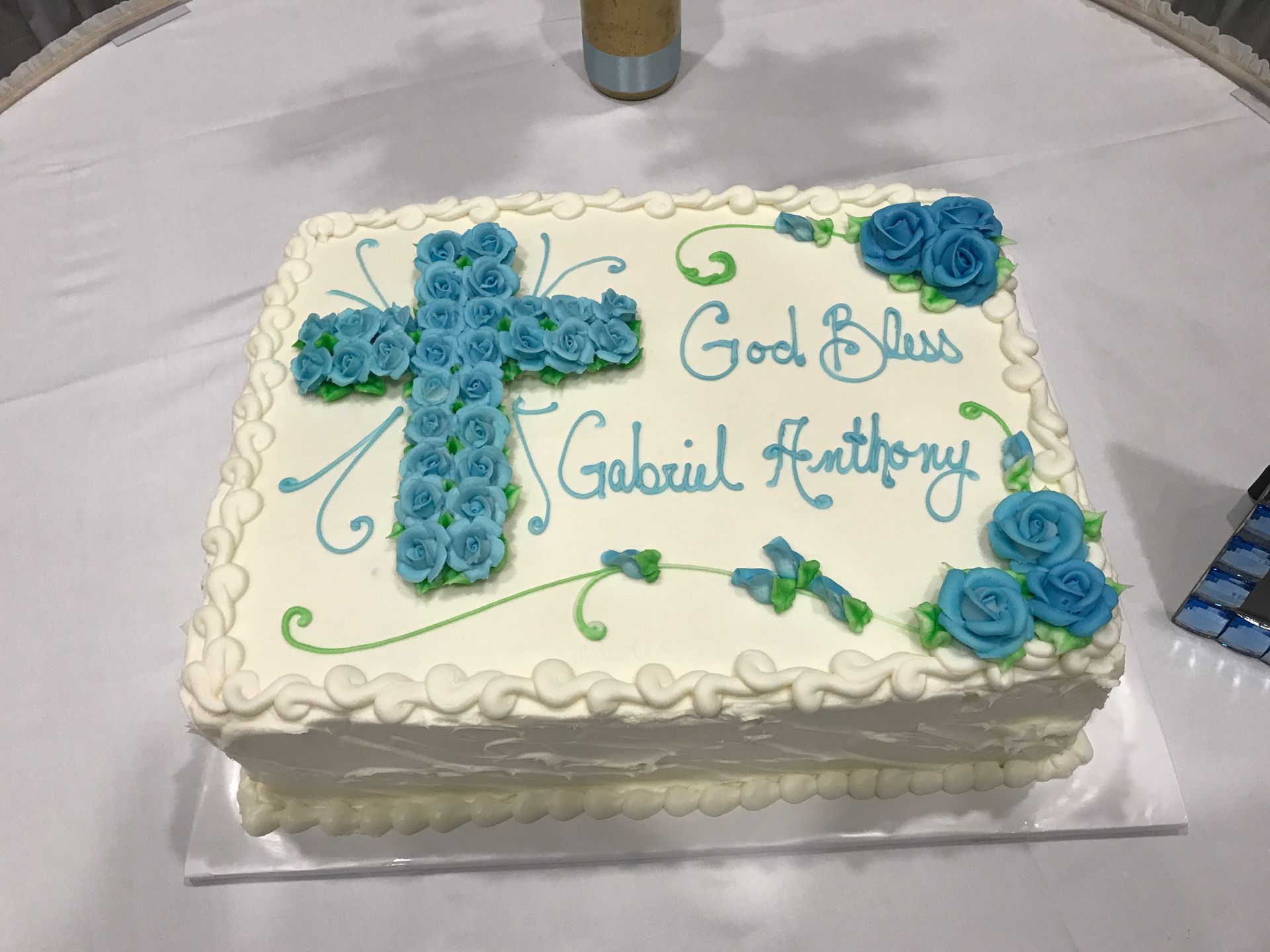 a white cake with a blue cross and the name gabriel on it