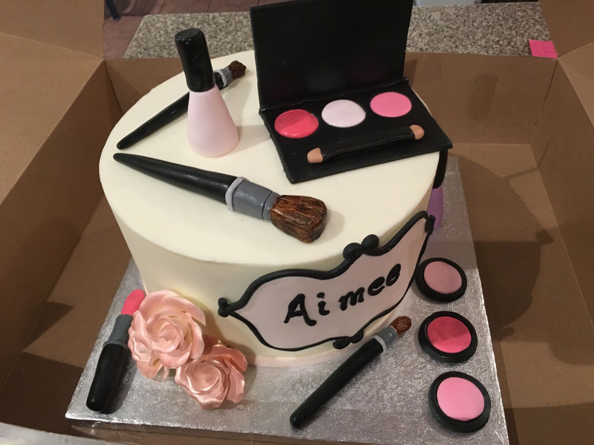 a cake decorated with makeup and the name ai mee