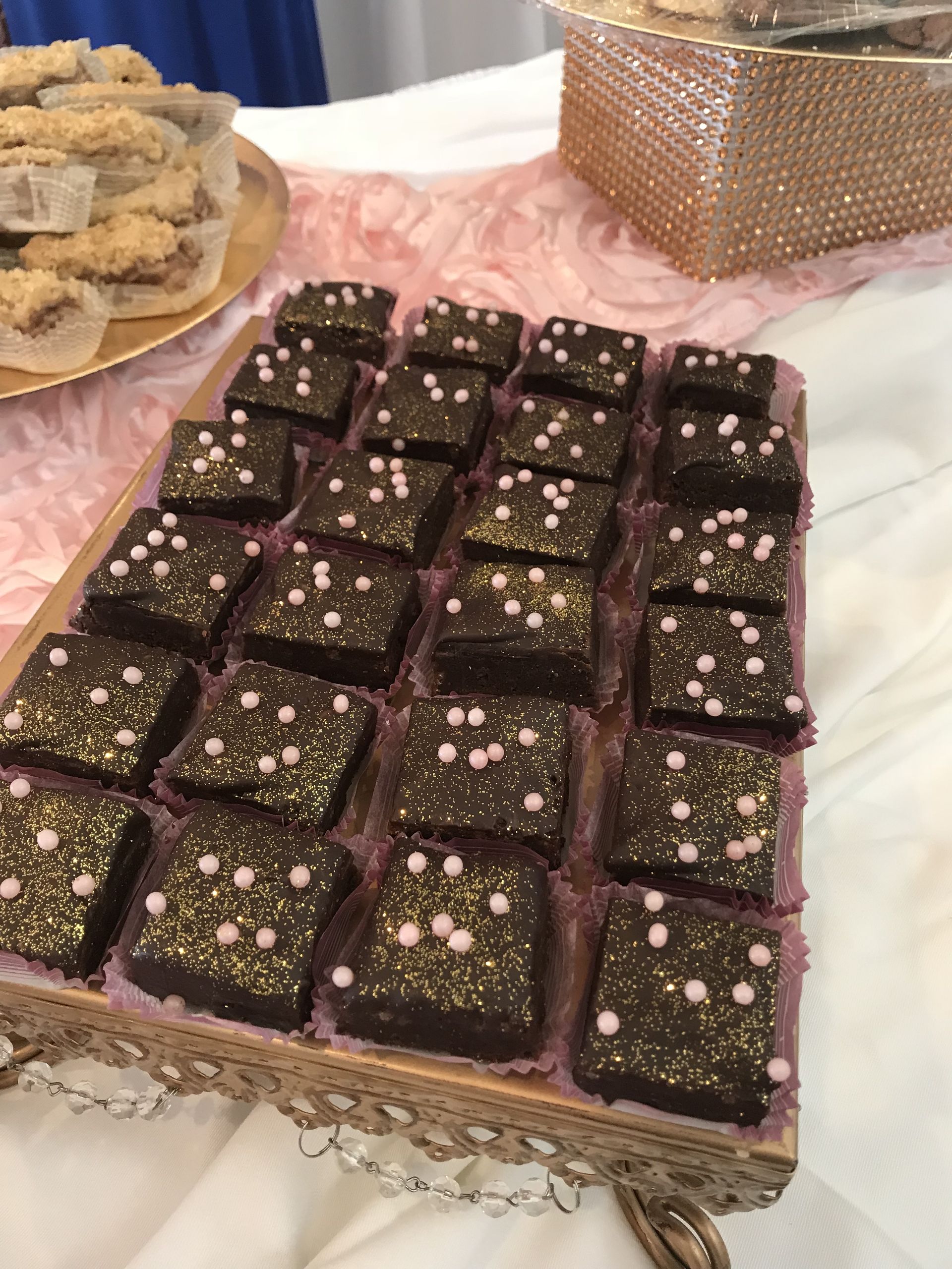 a tray of brownies with gold sprinkles on them