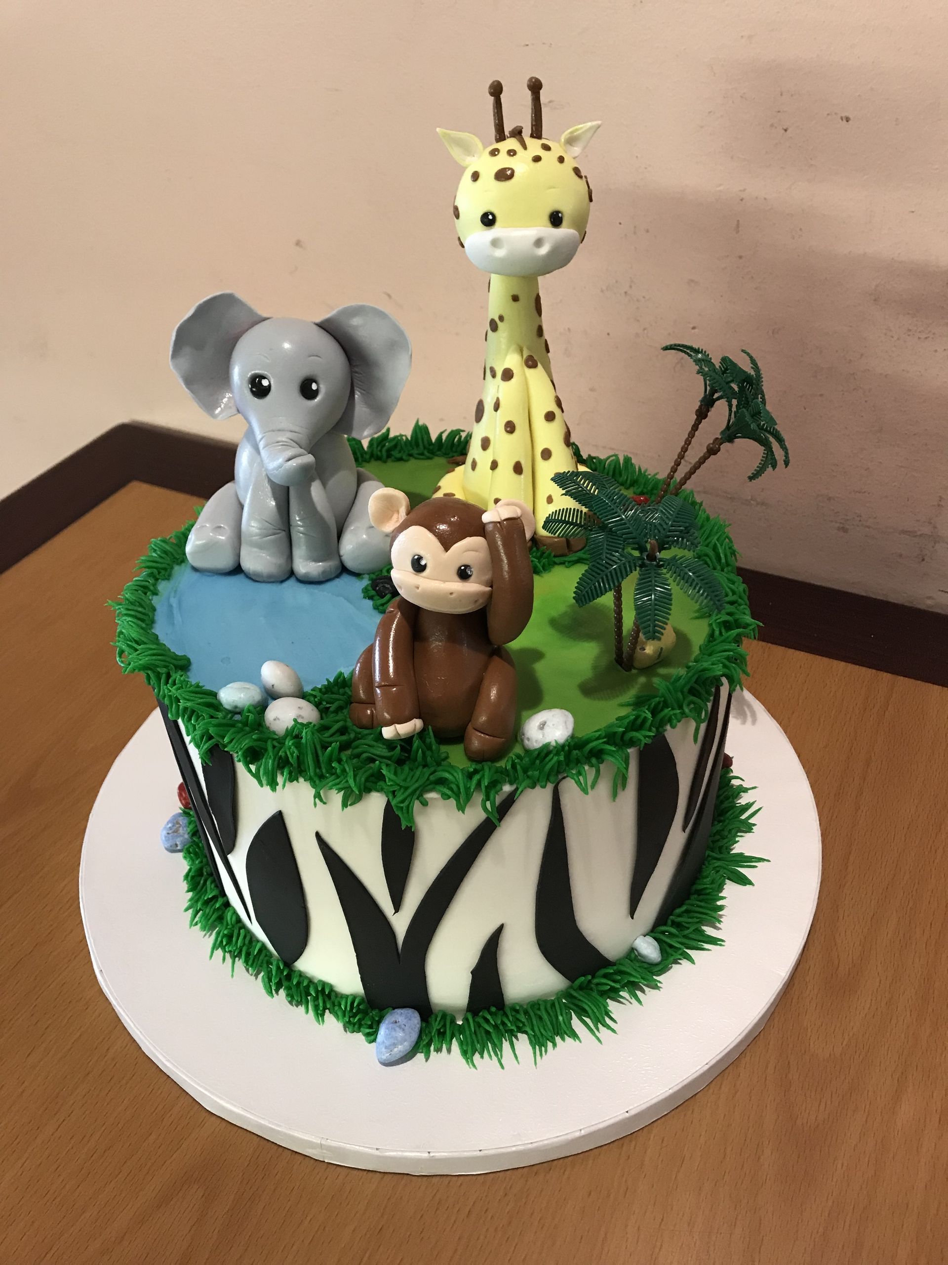 a cake with an elephant a giraffe and a monkey on it