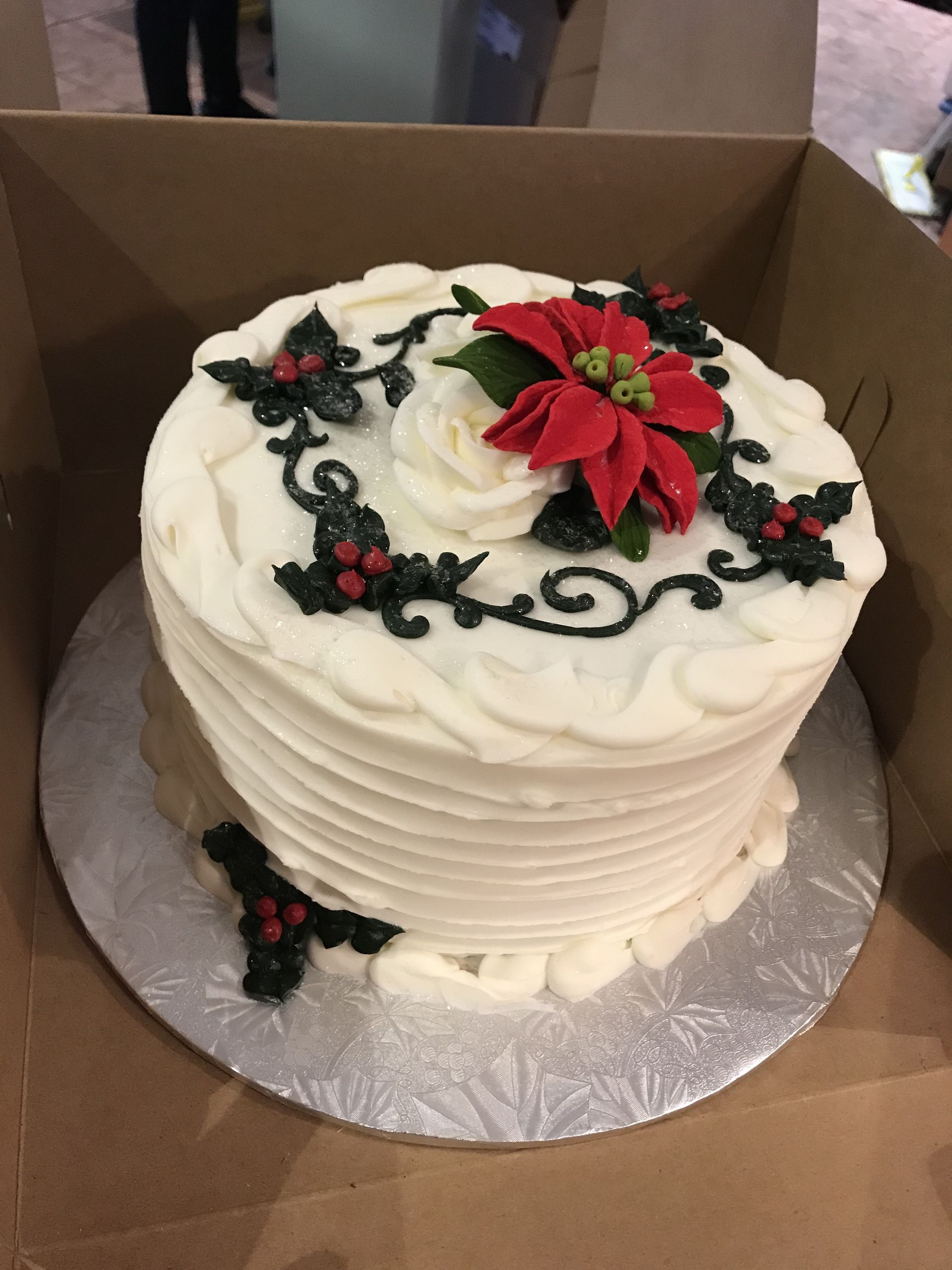 a white cake with a poinsettia and holly on top