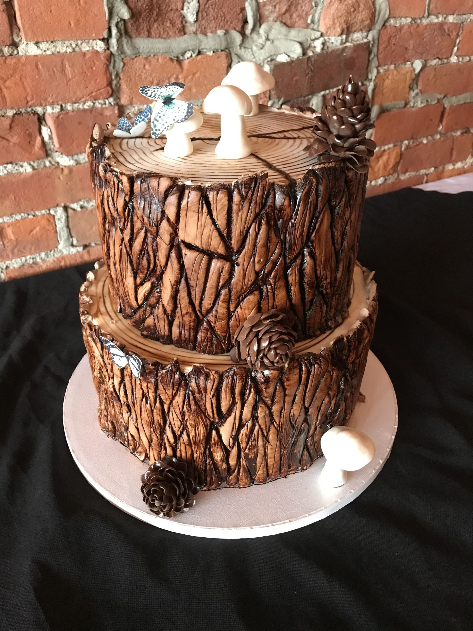 a cake that looks like a tree stump with mushrooms and pine cones on it