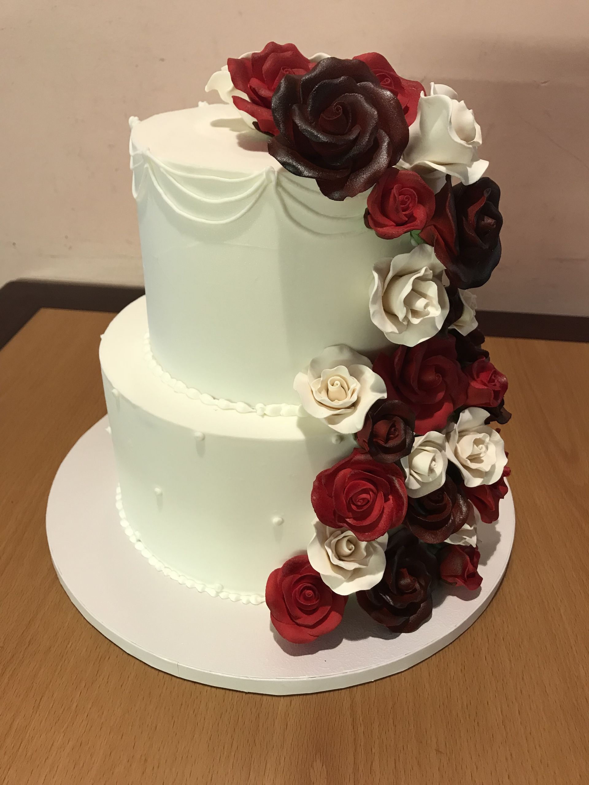 a white cake with red and white roses on it