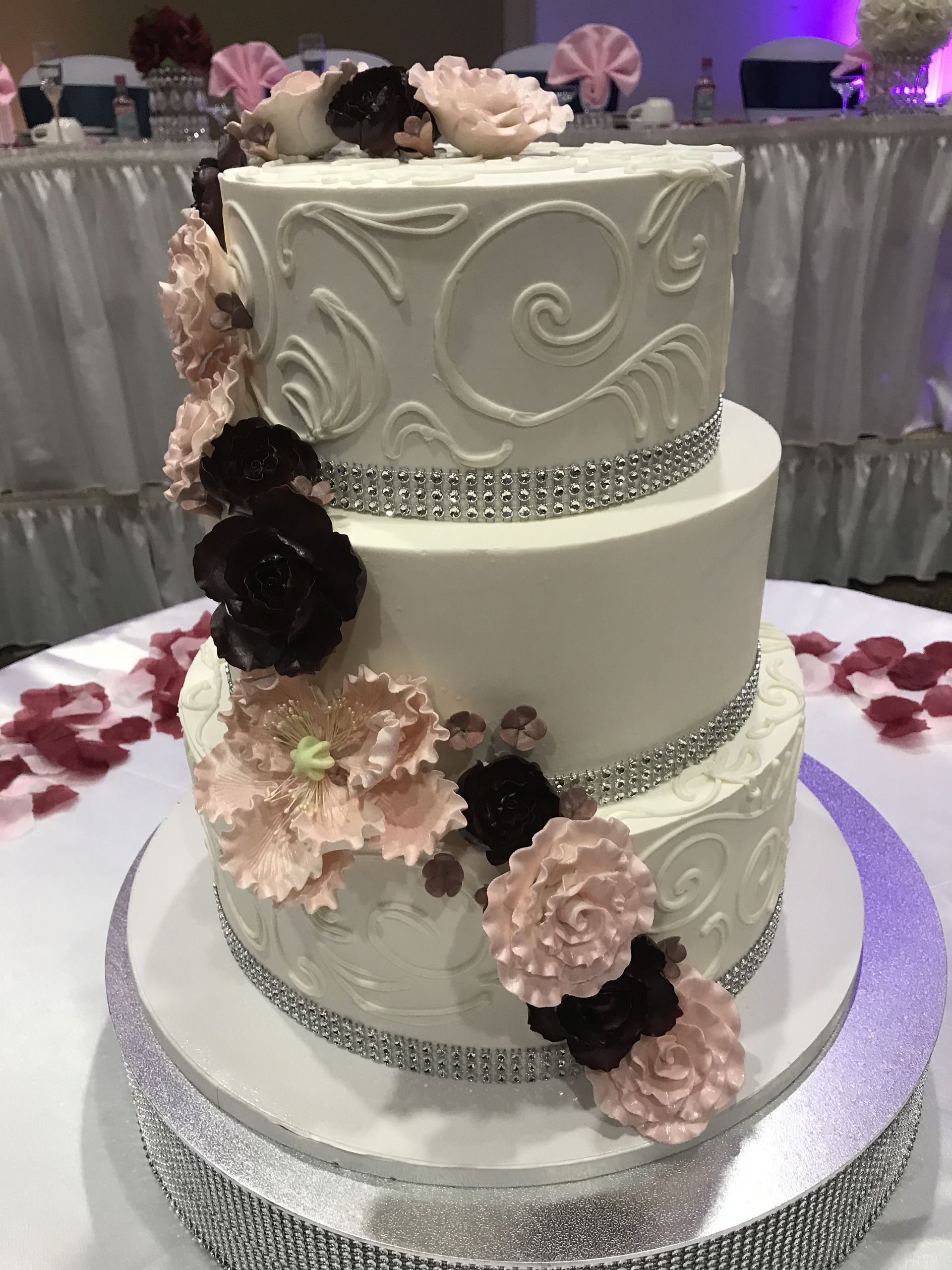 a wedding cake with flowers and rhinestones on it