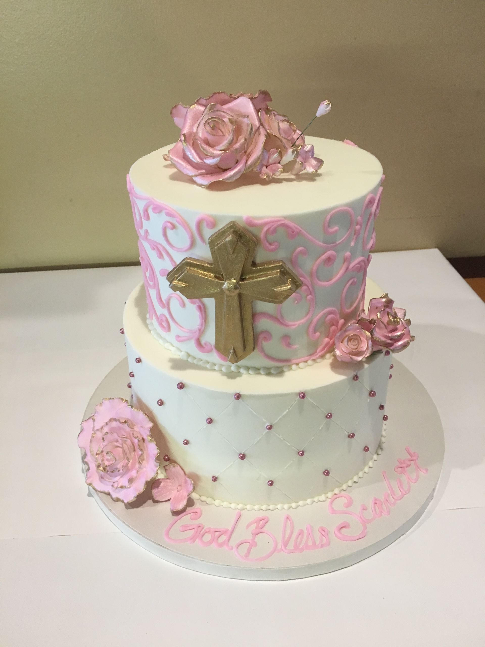 a cake with a cross and pink roses on it