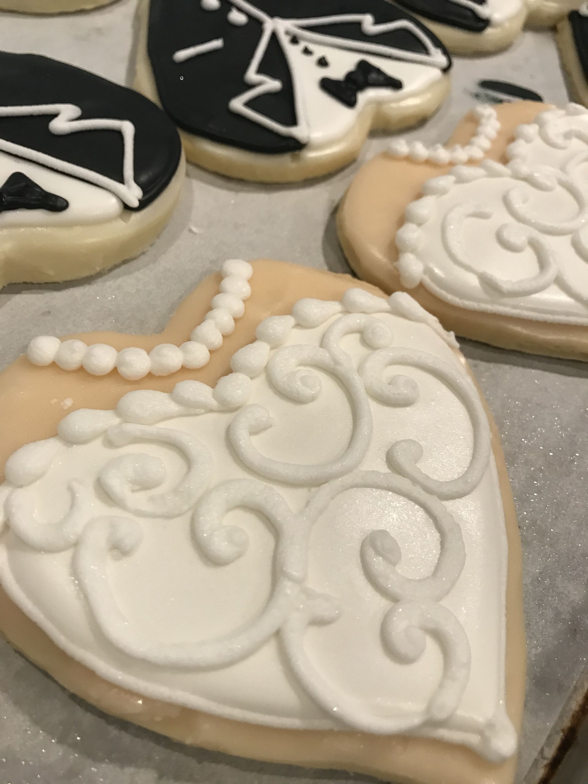 a heart shaped cookie with a bride and groom design on it