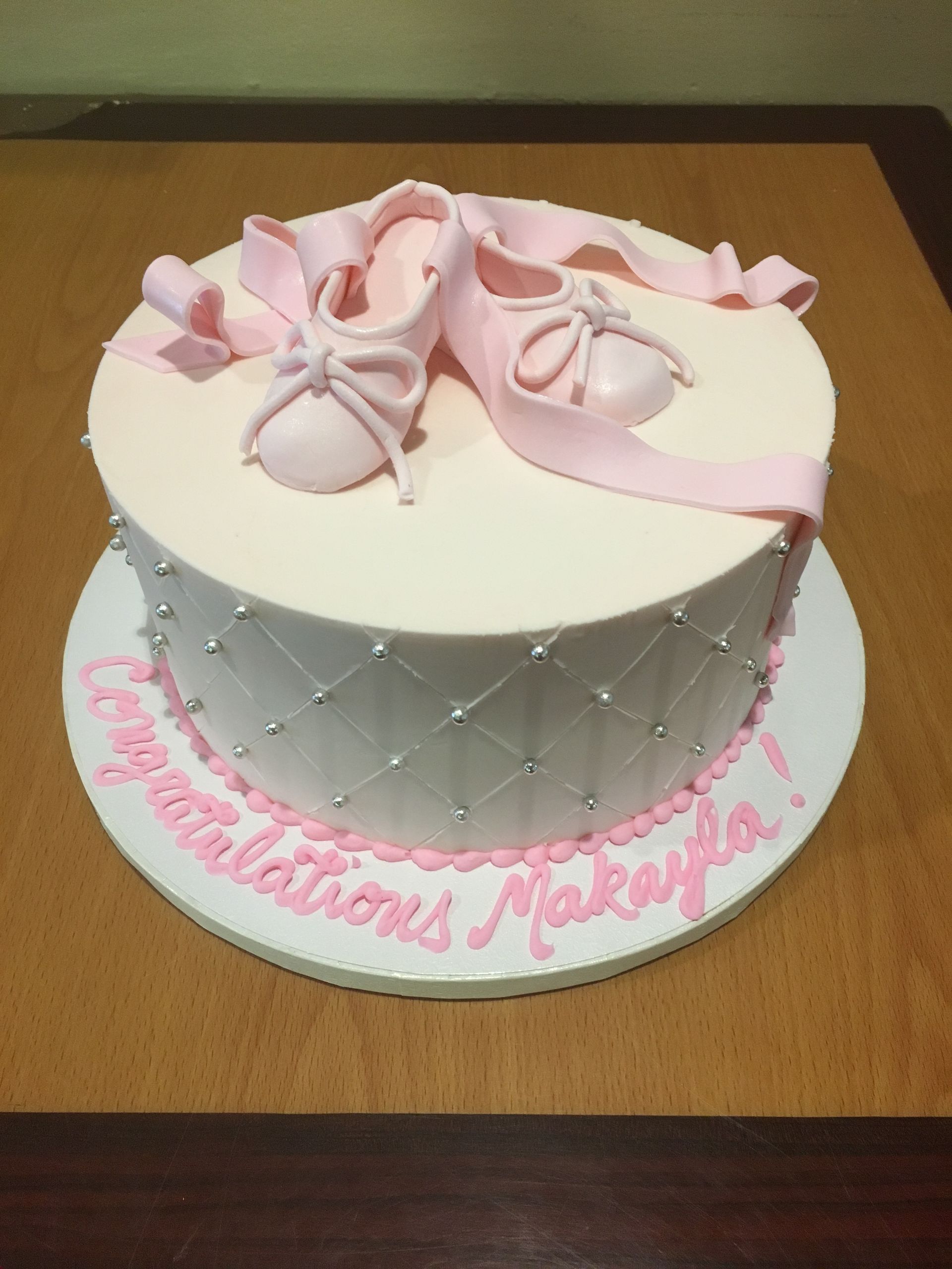 a cake with a pair of pink ballet shoes on it