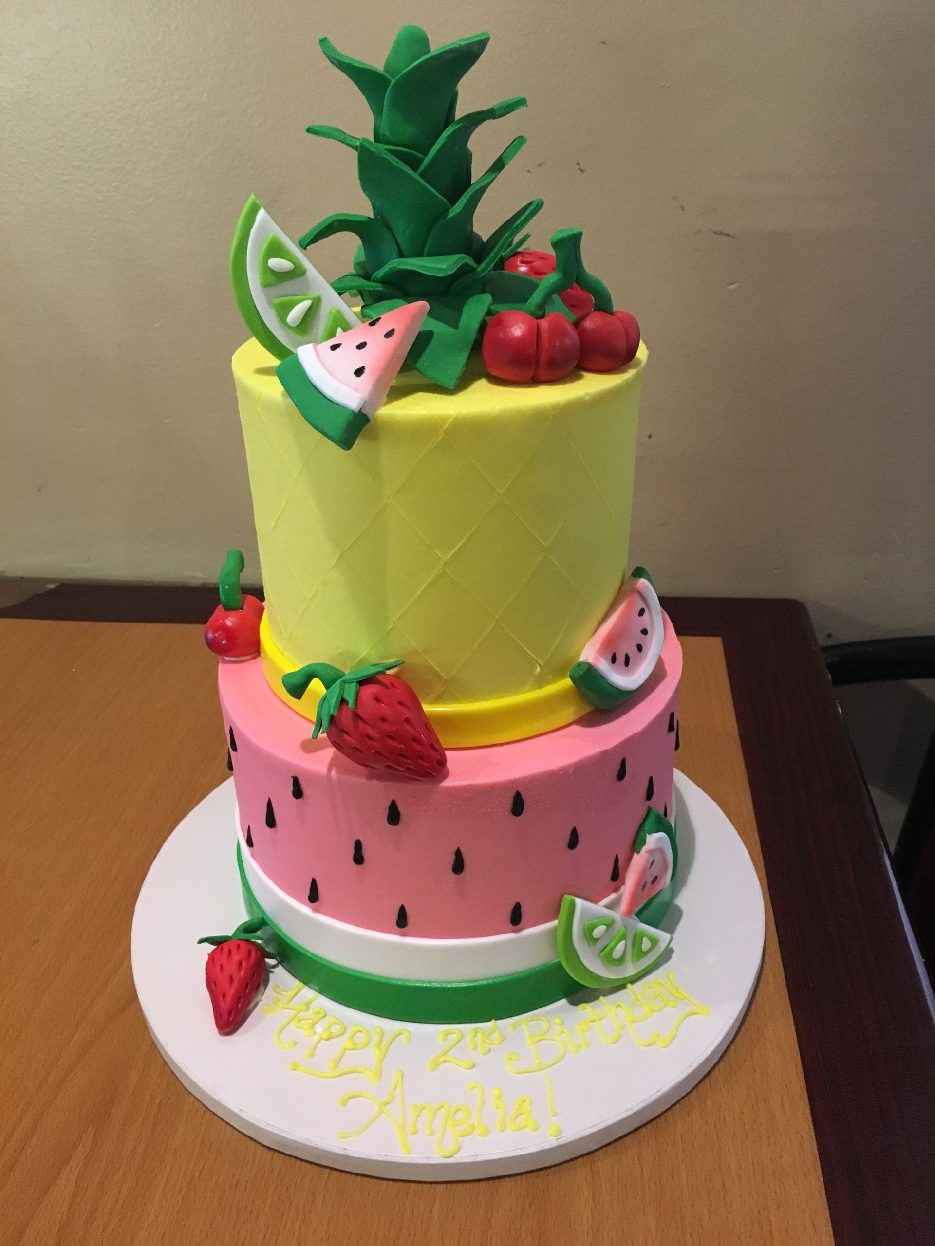 a birthday cake with strawberries and watermelon on it