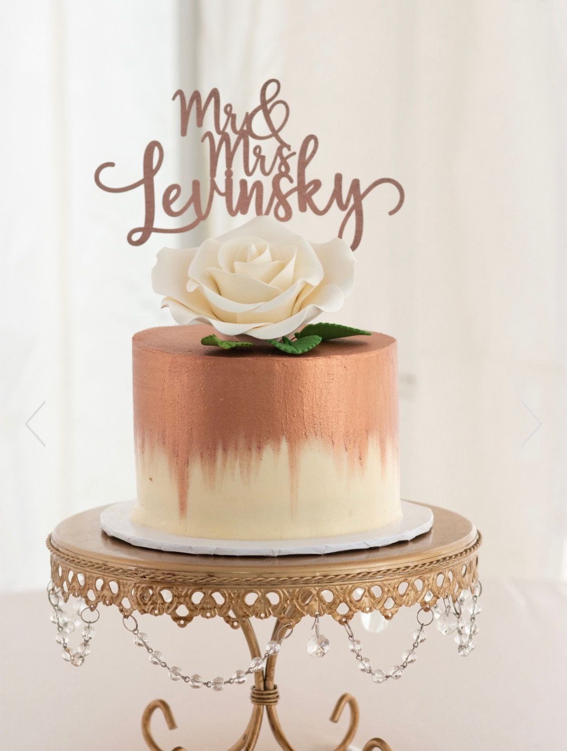 a cake with a rose on top of it is on a cake stand .