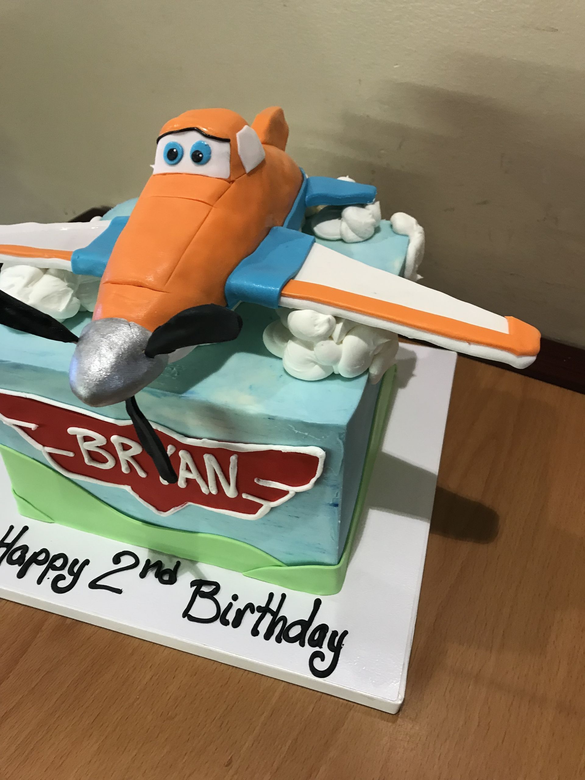 a birthday cake for brian with an airplane on top