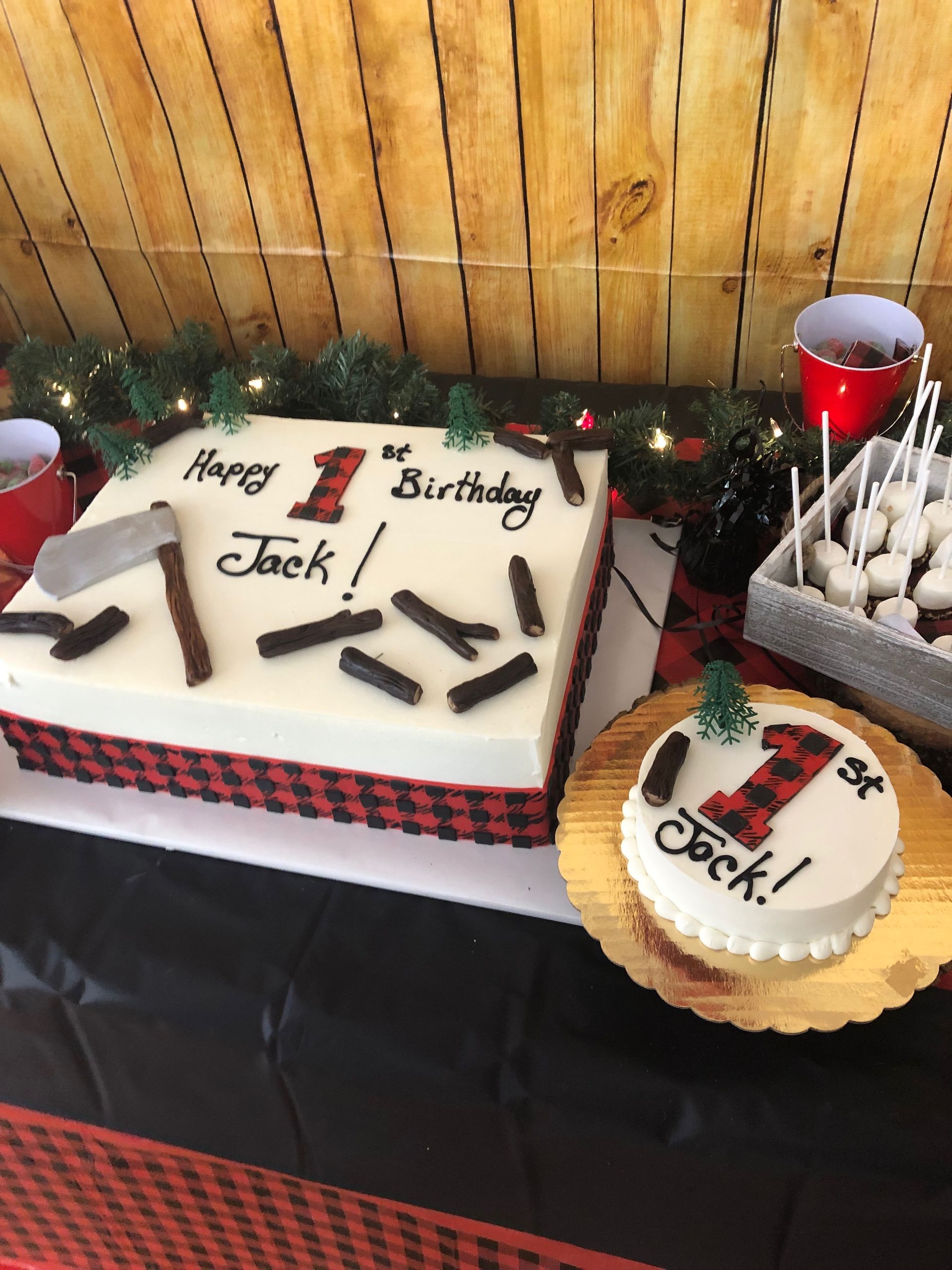 a birthday cake is sitting on a table with a wooden wall in the background .