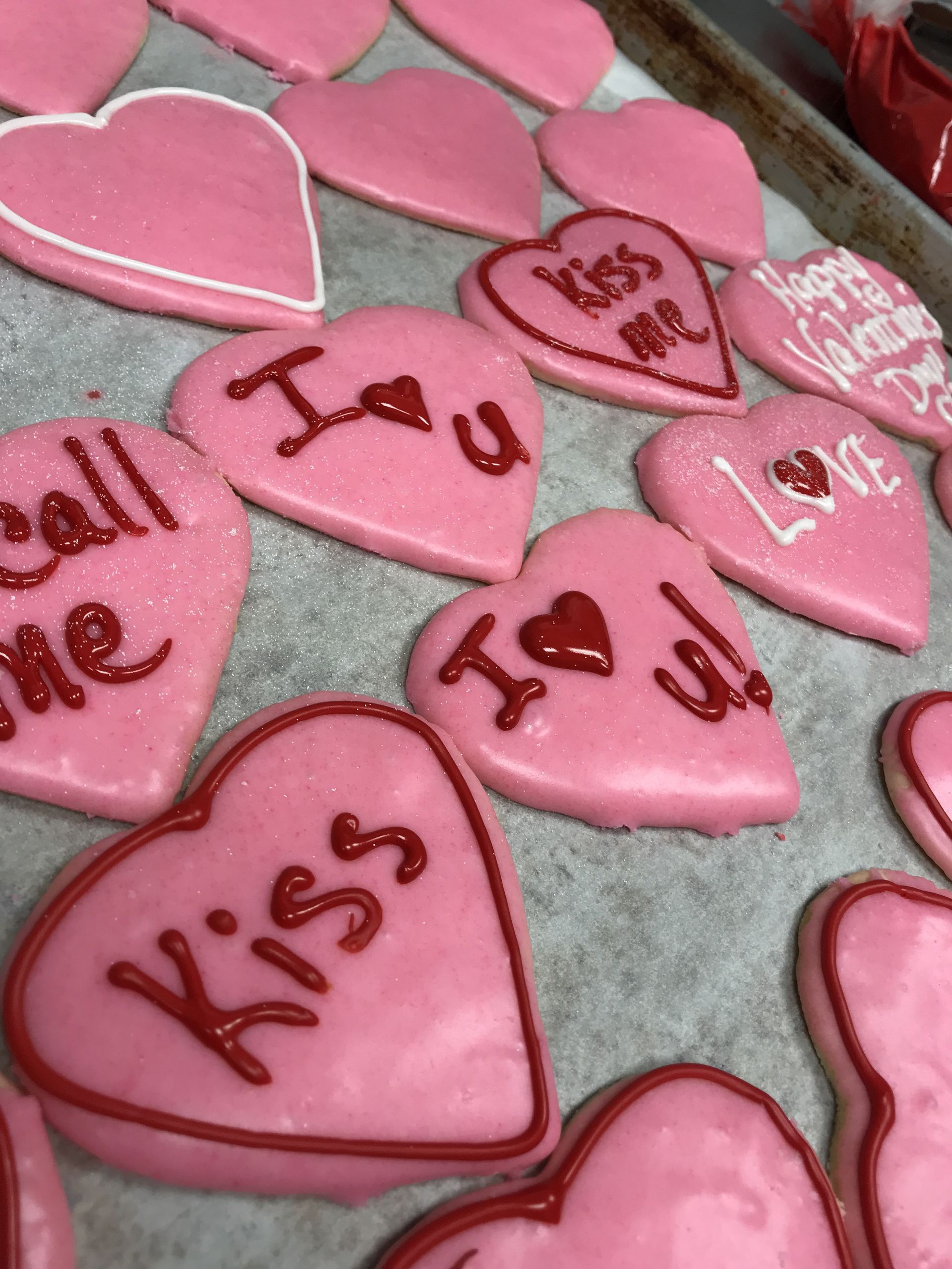 a bunch of pink heart shaped cookies that say kiss i love you