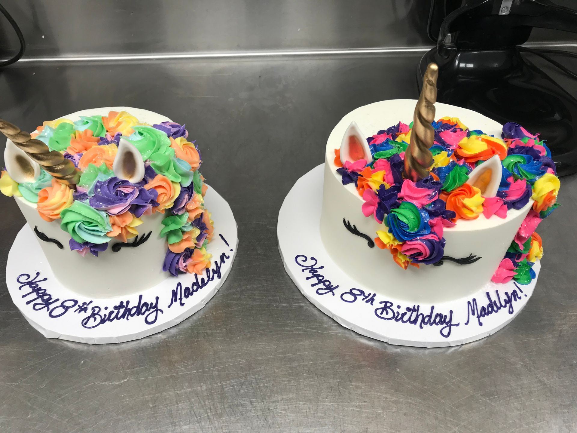 two unicorn birthday cakes are sitting on a counter .