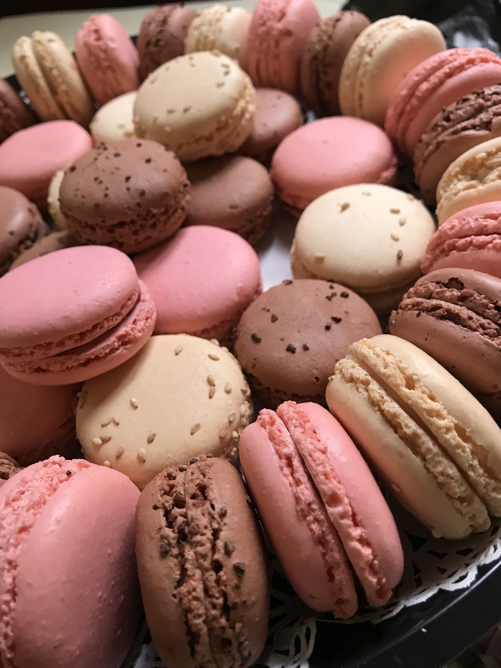 a tray of macarons of different colors and flavors