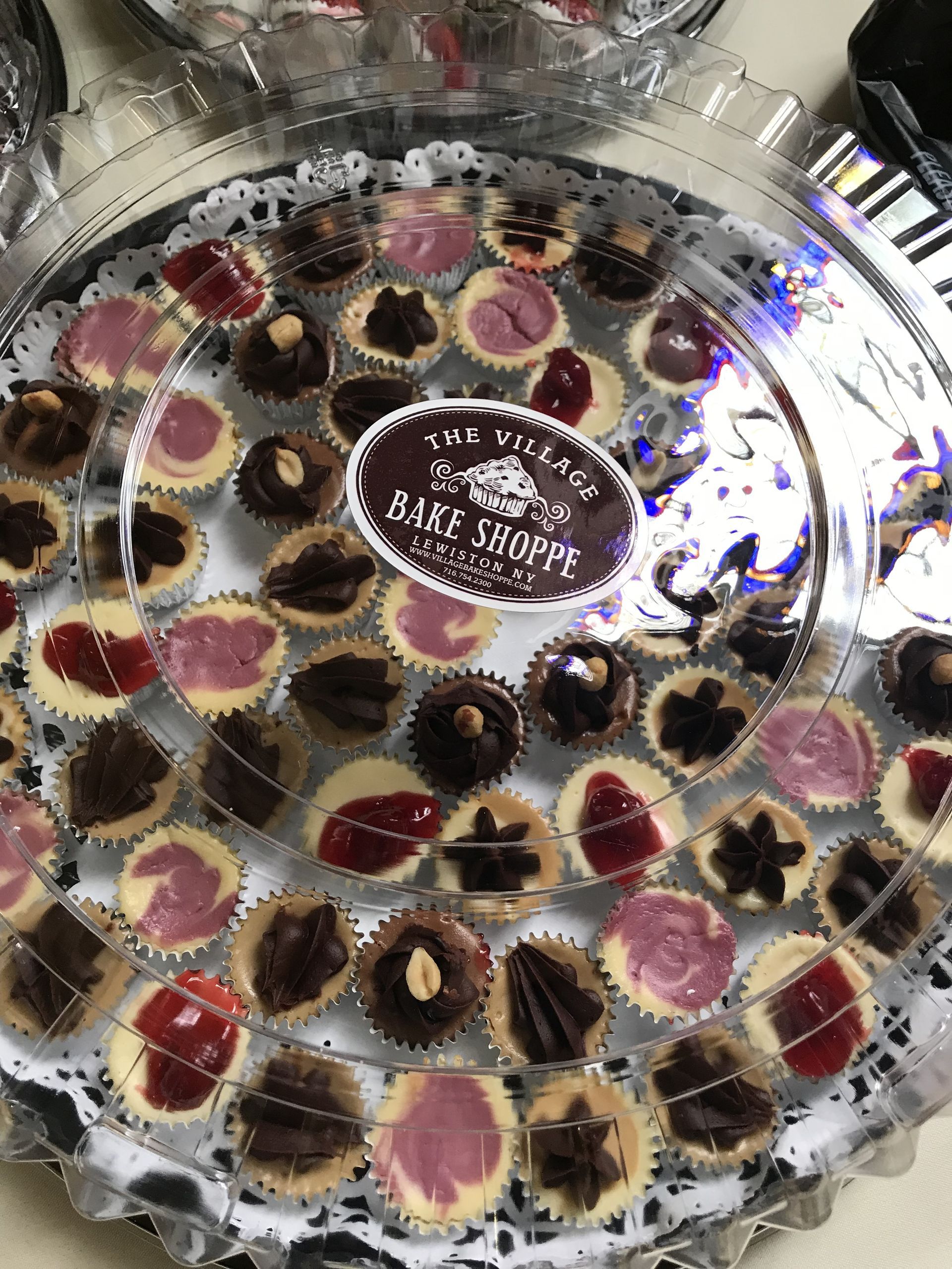 a tray of cupcakes with hearts on them is sitting on a table .