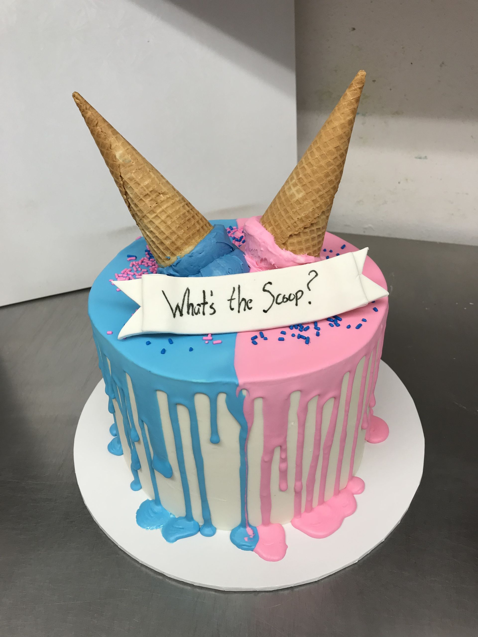 a blue and pink cake with ice cream cones and a banner that says what 's the soup