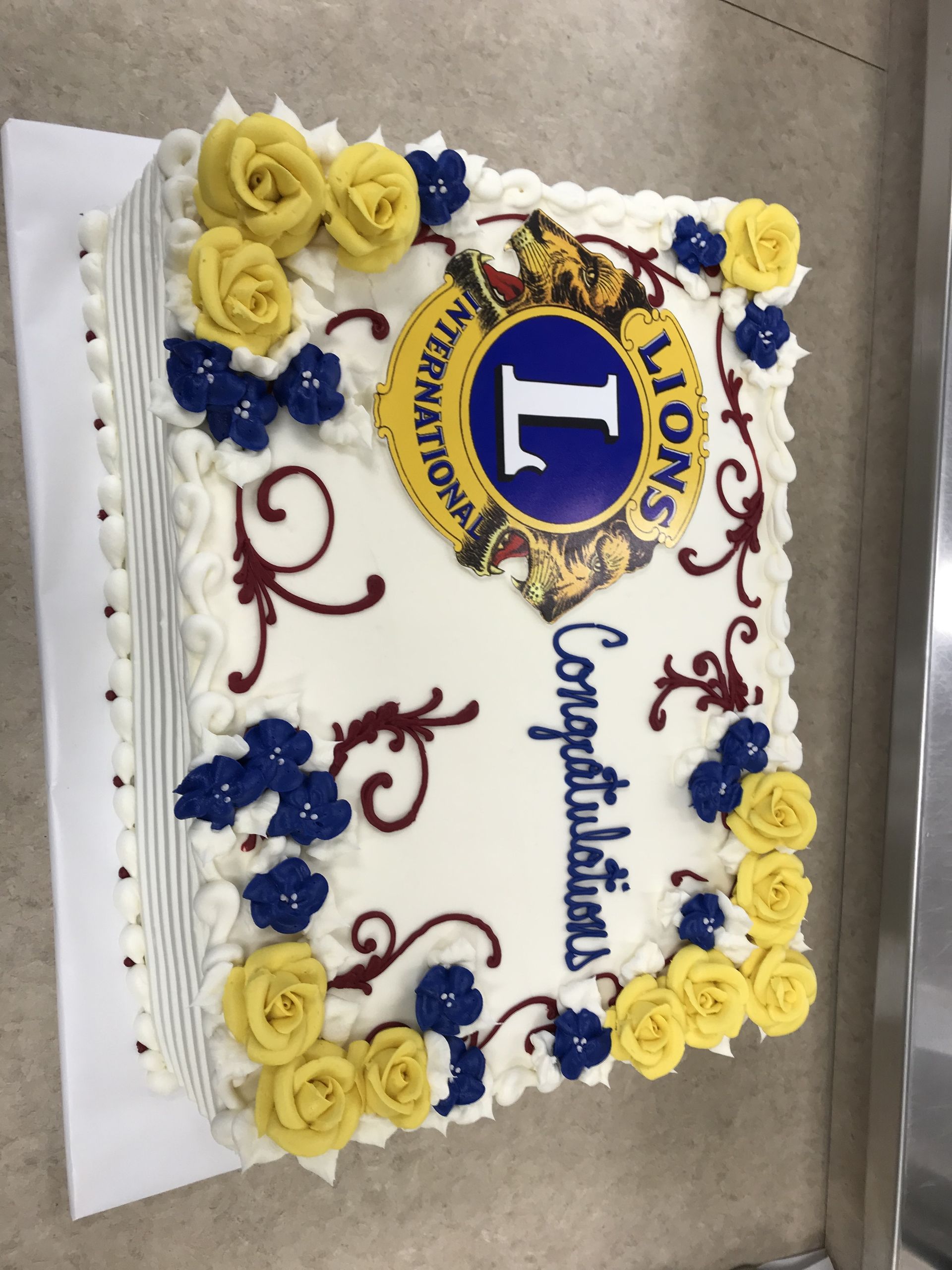 a lion 's international cake with yellow and blue flowers