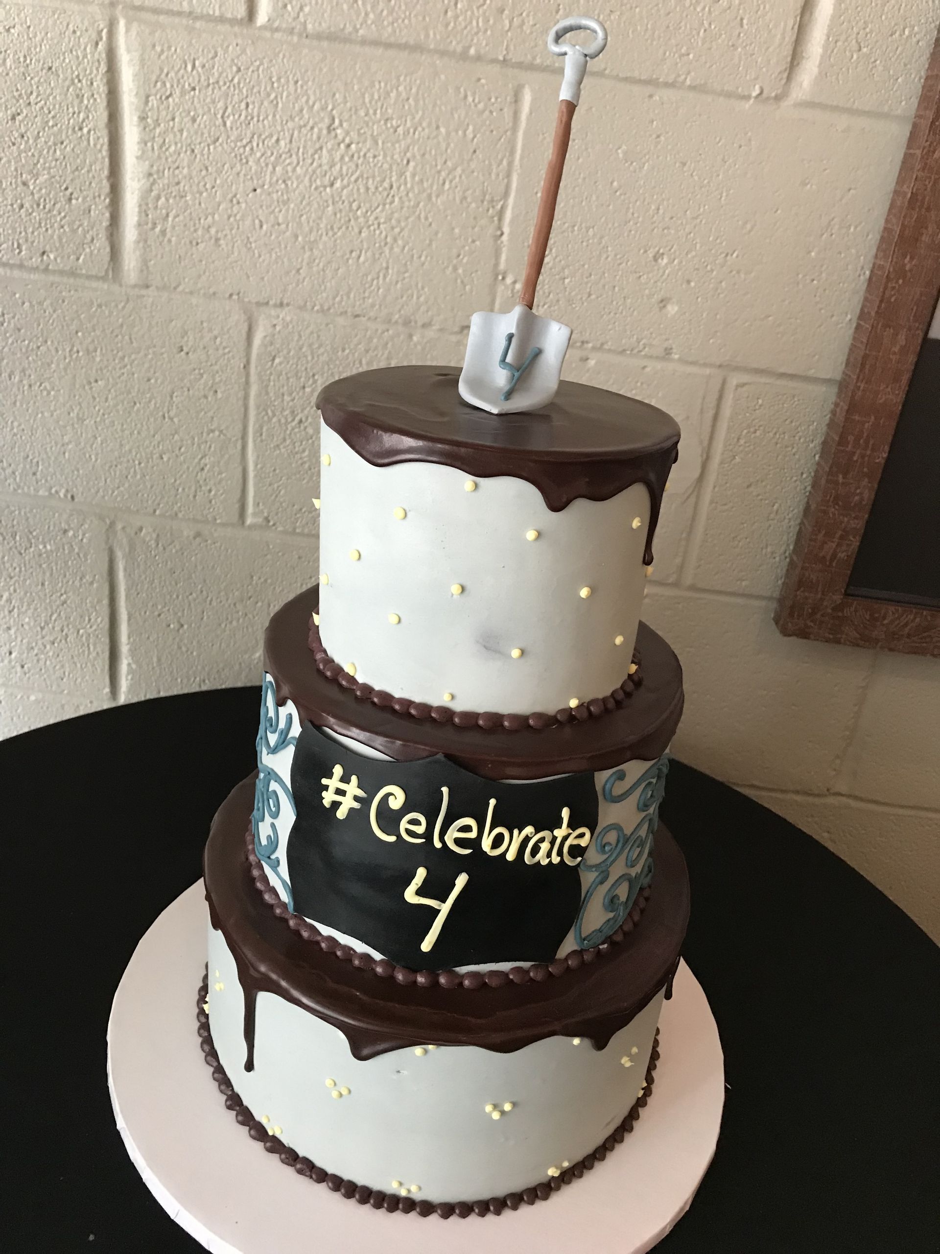 a cake with a shovel on top that says celebrate 4