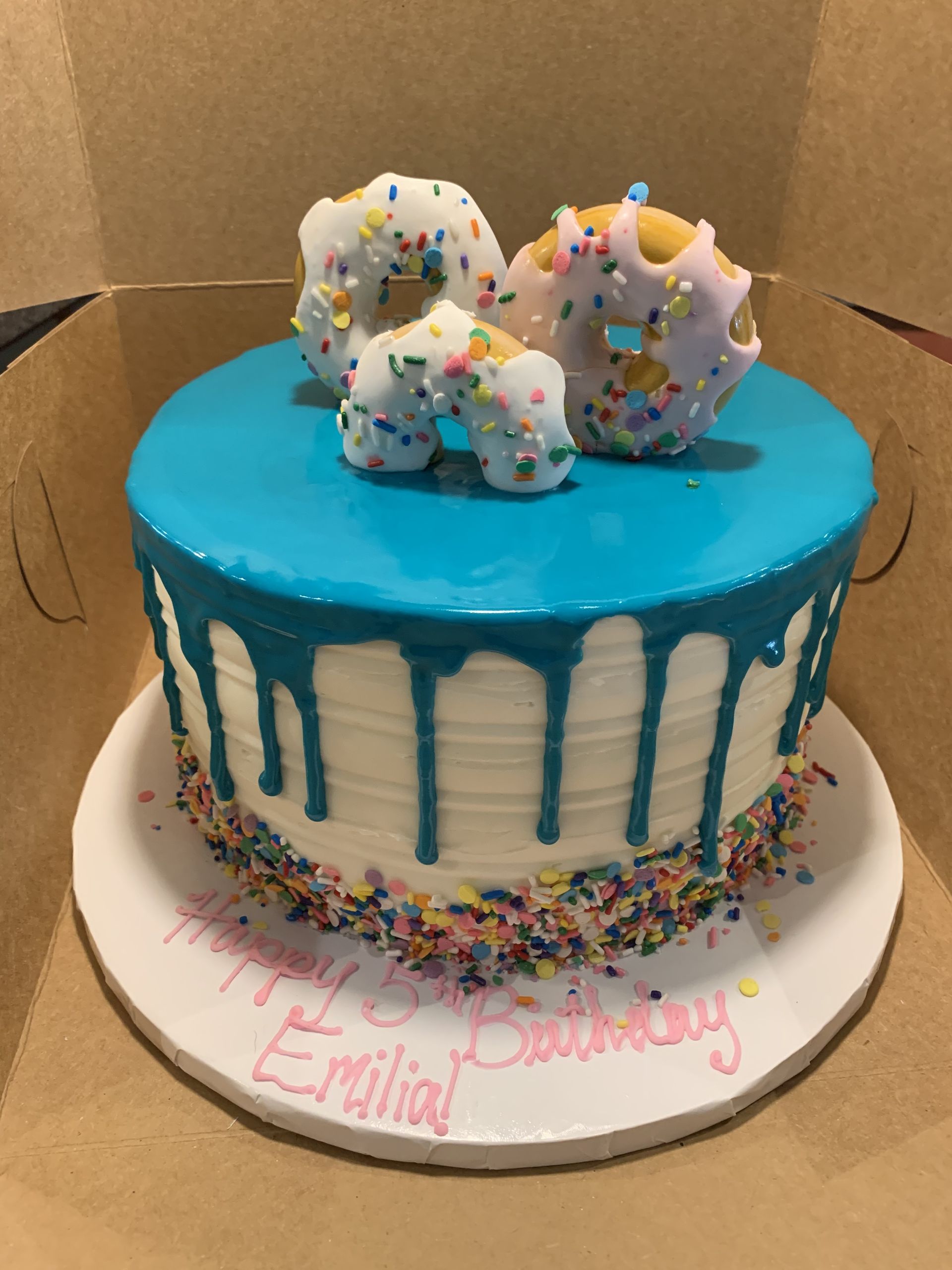 a birthday cake with donuts and sprinkles on it