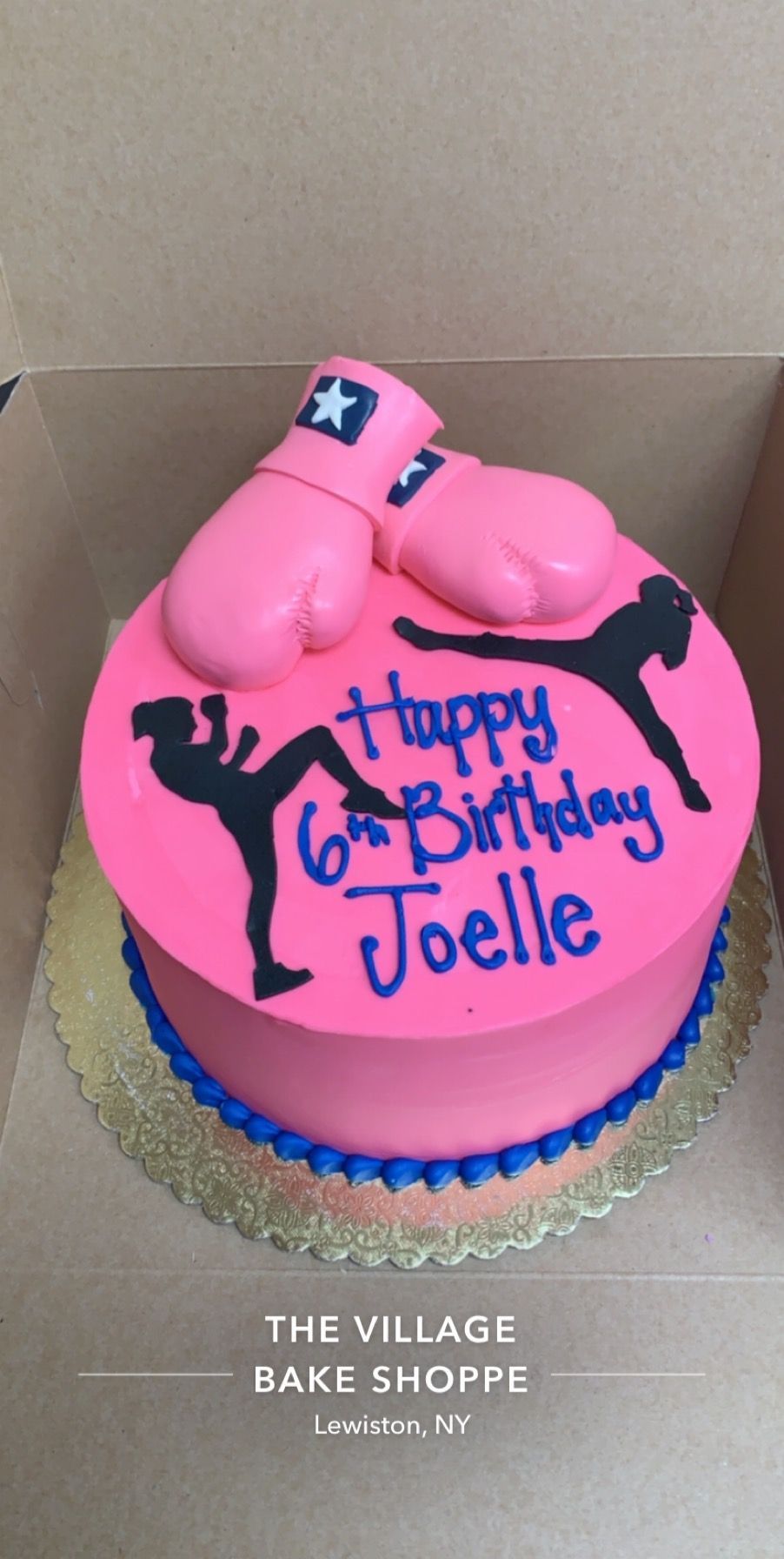 a pink cake with boxing gloves and the words happy 6th birthday joelle