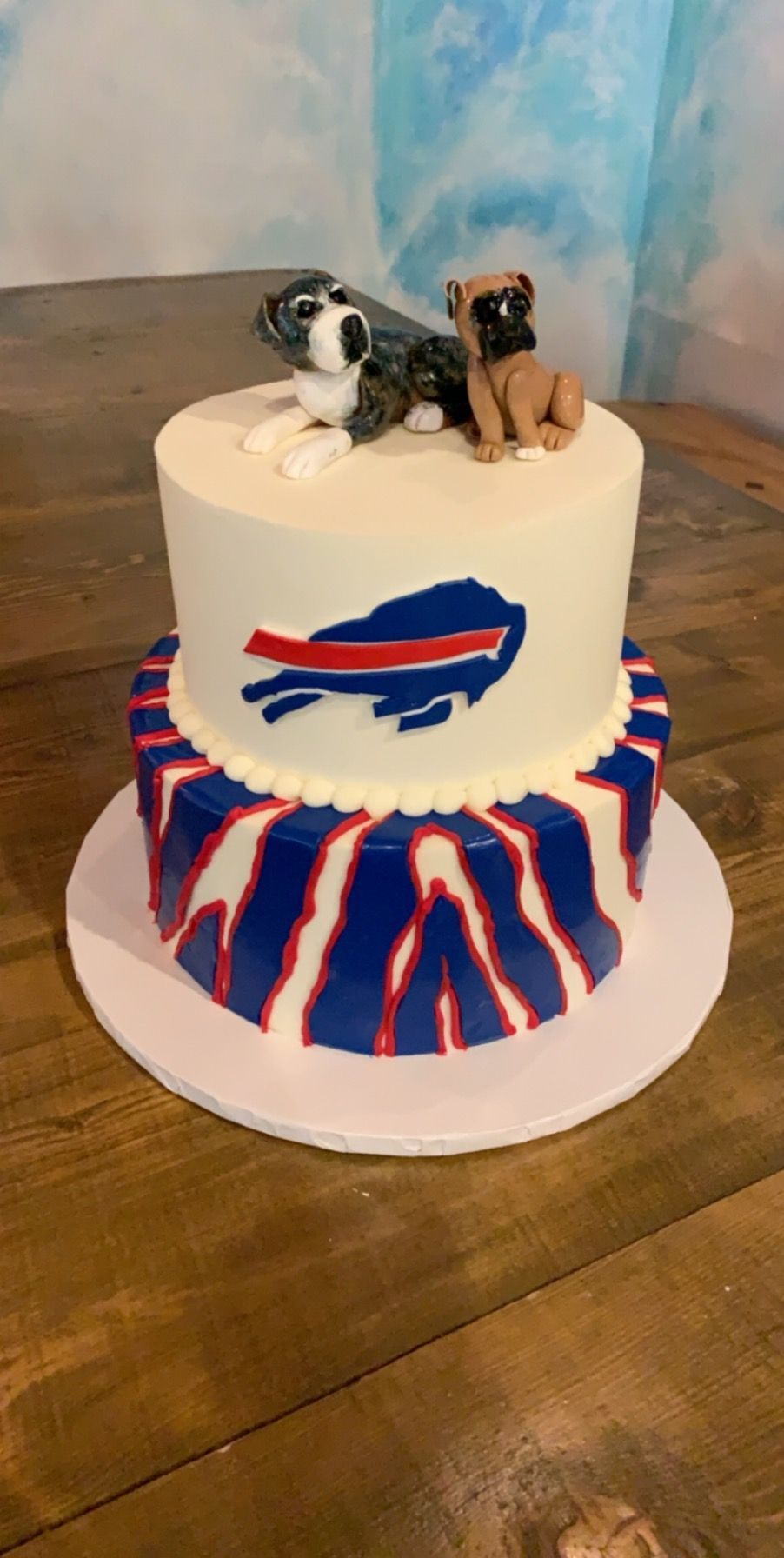 a buffalo bills cake with two pugs on top of it .