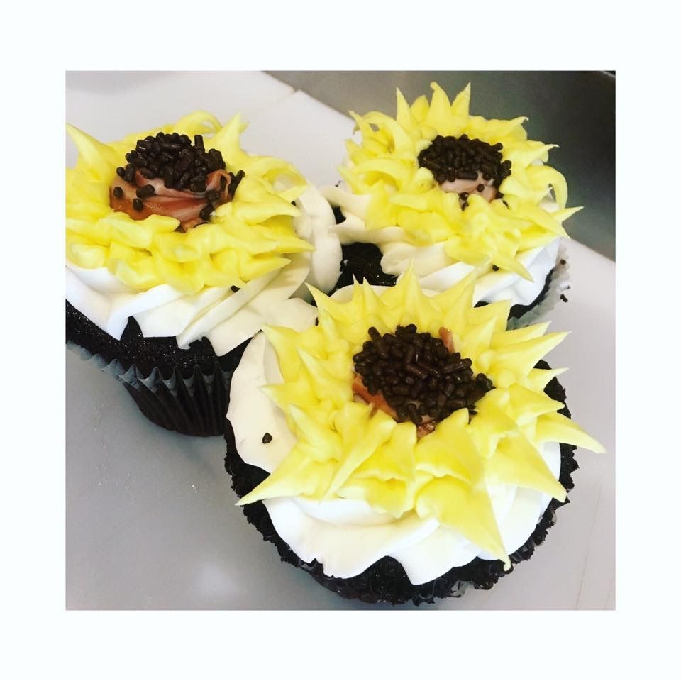 three cupcakes decorated with yellow frosting and chocolate sprinkles