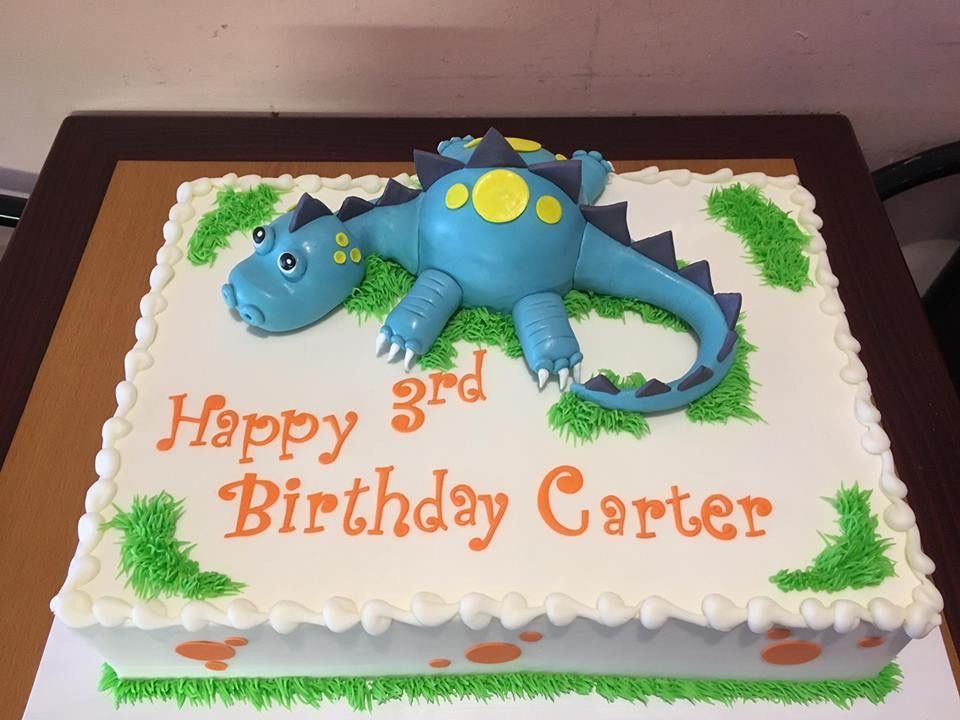 a birthday cake for carter with a blue dinosaur on it
