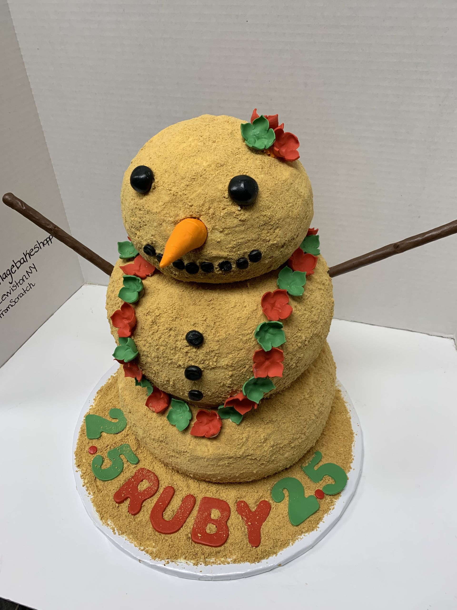 a cake in the shape of a snowman with the name ruby on it