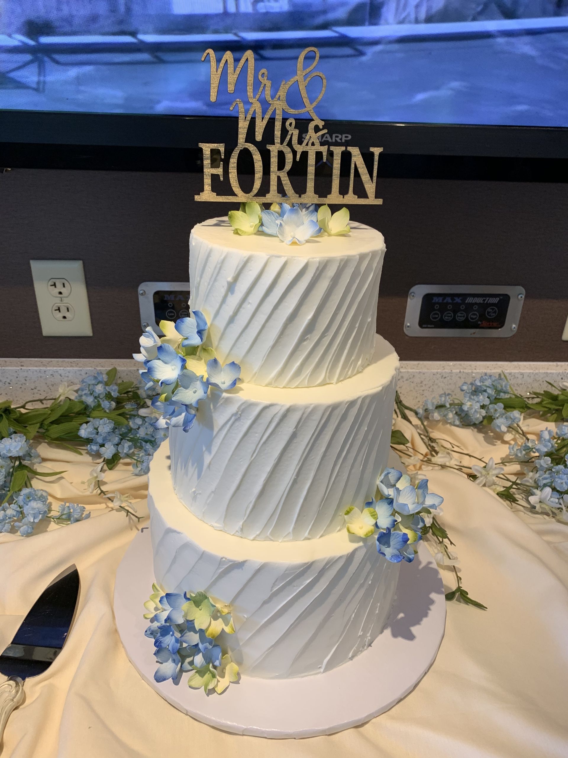 a white wedding cake with a topper that says mr. and mrs. fortune
