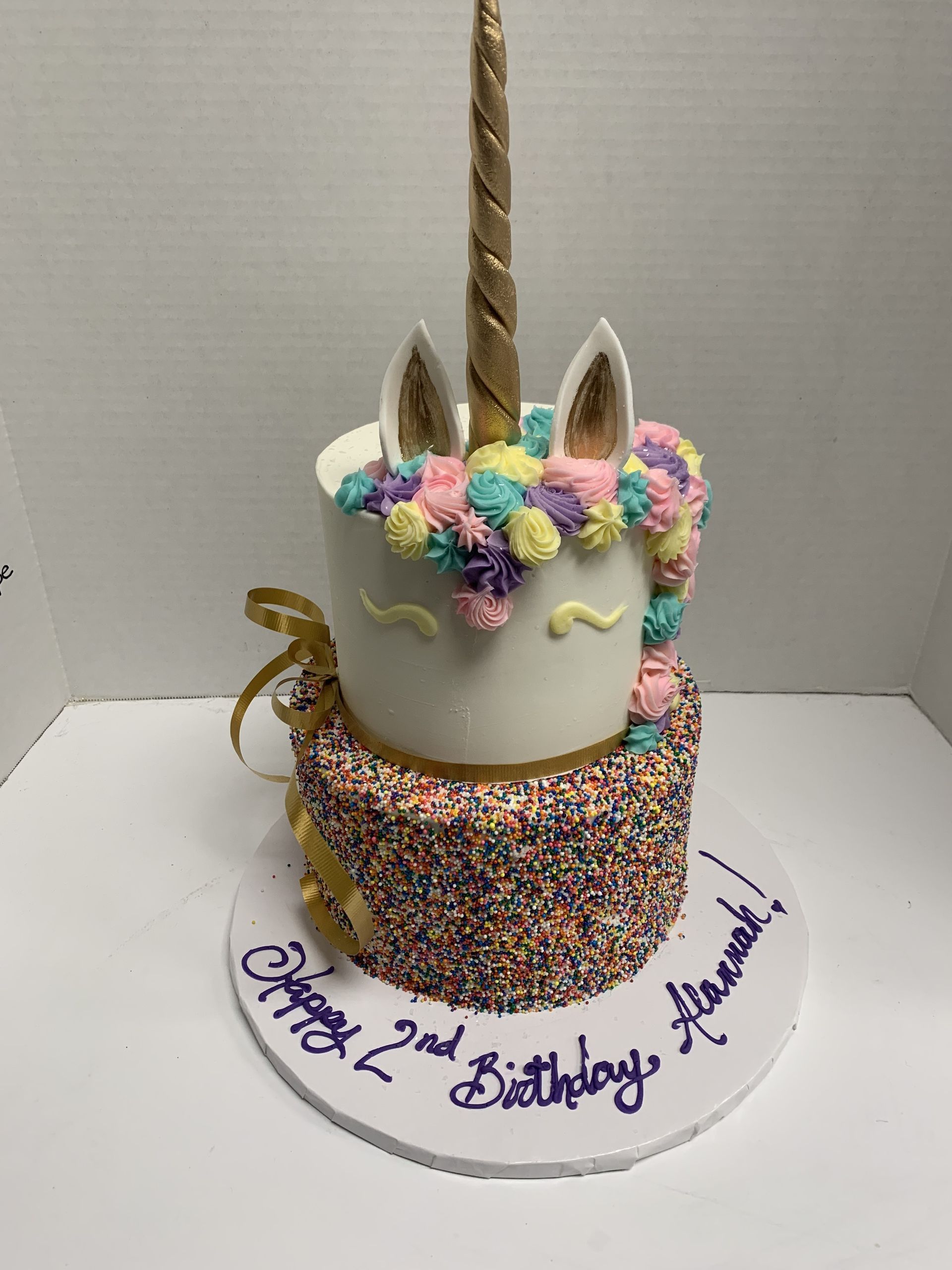 a birthday cake with a unicorn on top of it