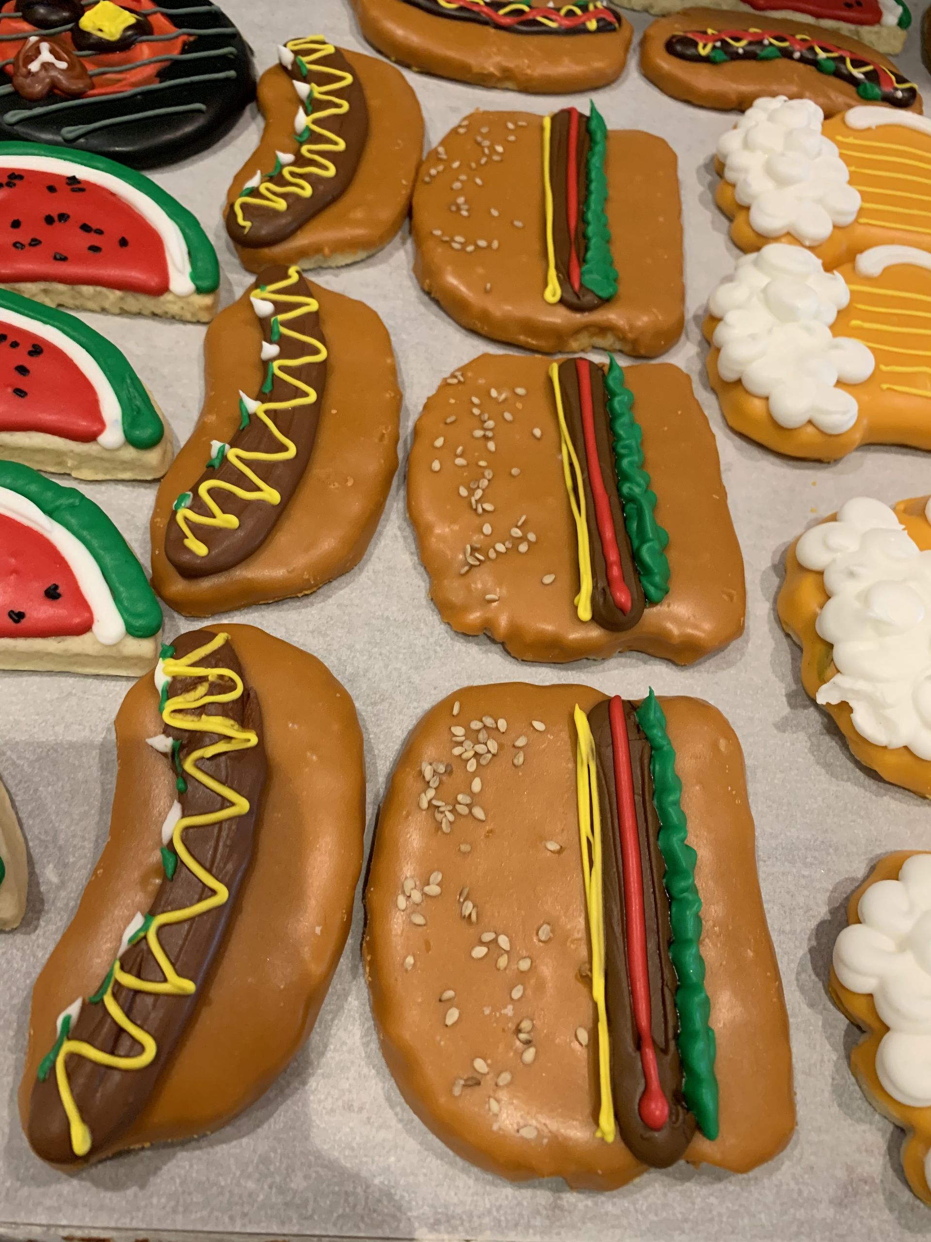 a bunch of cookies decorated to look like hot dogs and hamburgers