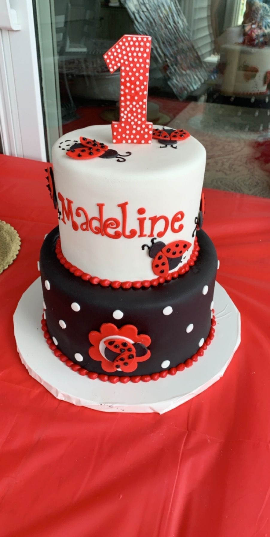 a black and white cake with ladybugs on it is on a table .