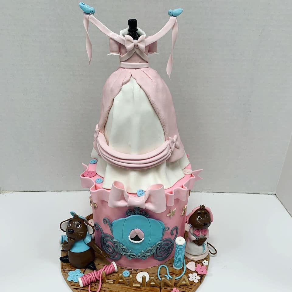 a pink and white cake with a dress on top