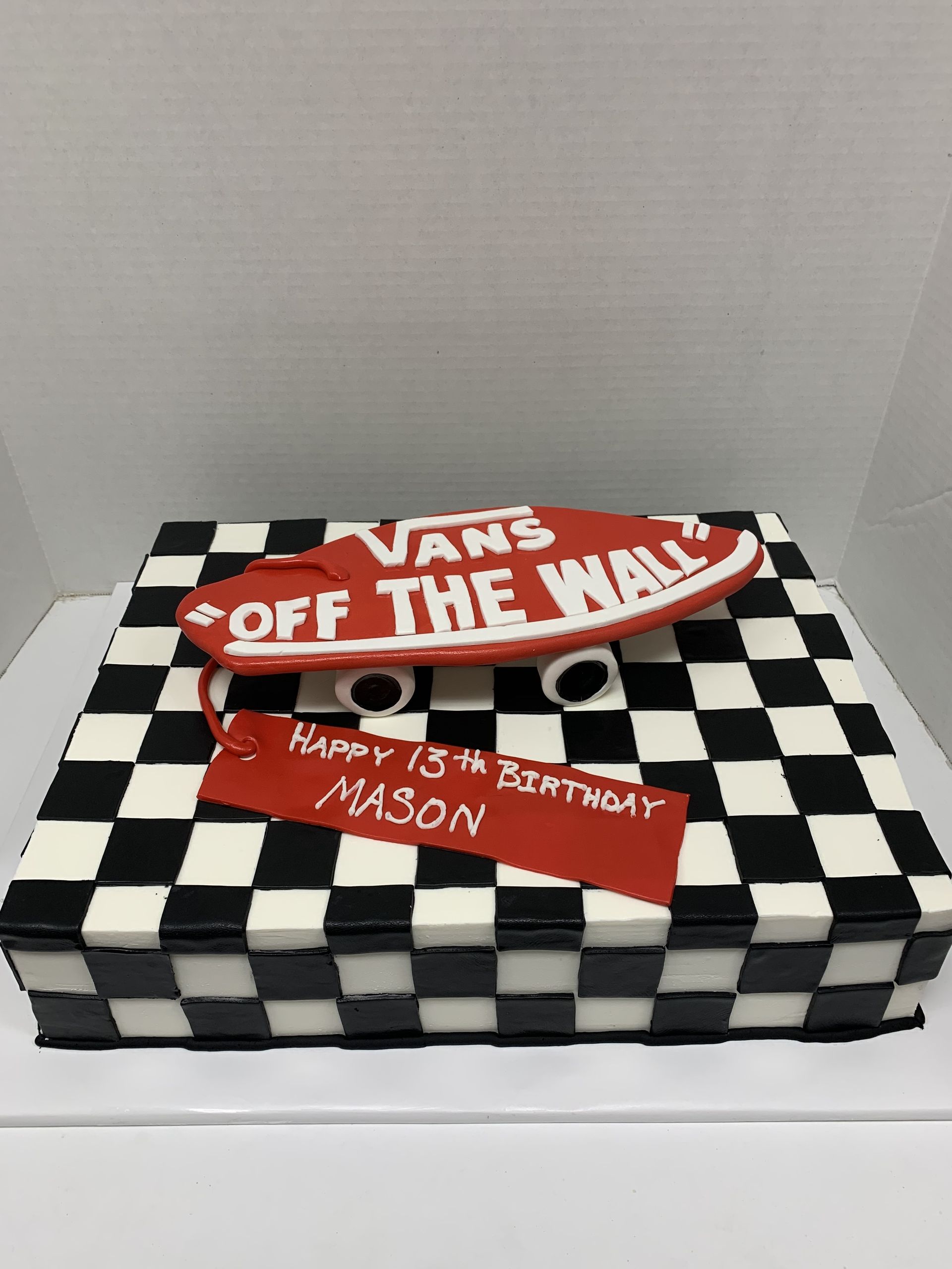 a vans off the wall cake with a checkered background