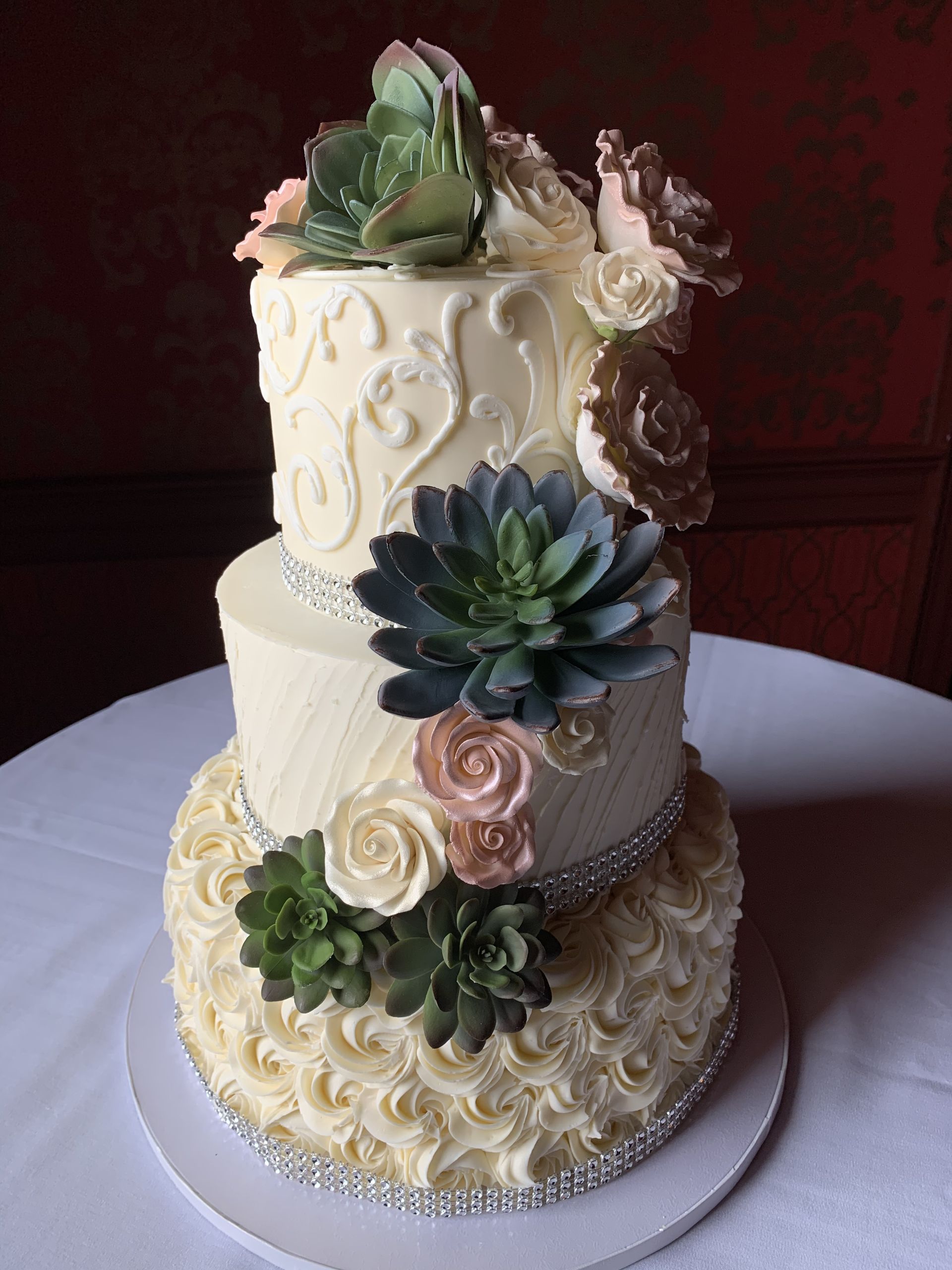 a wedding cake with flowers and succulents on it