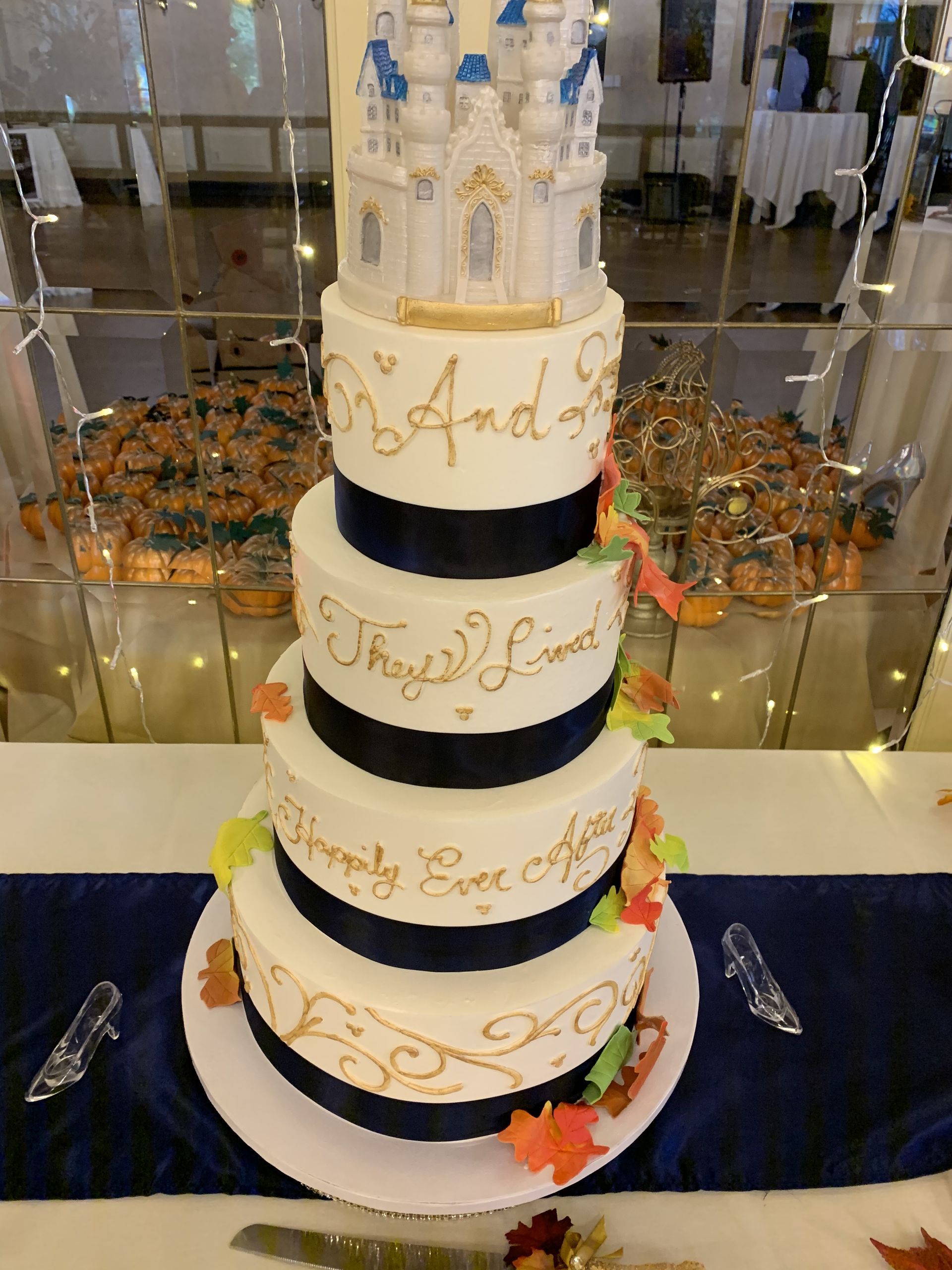a wedding cake with a castle on it is on a table .