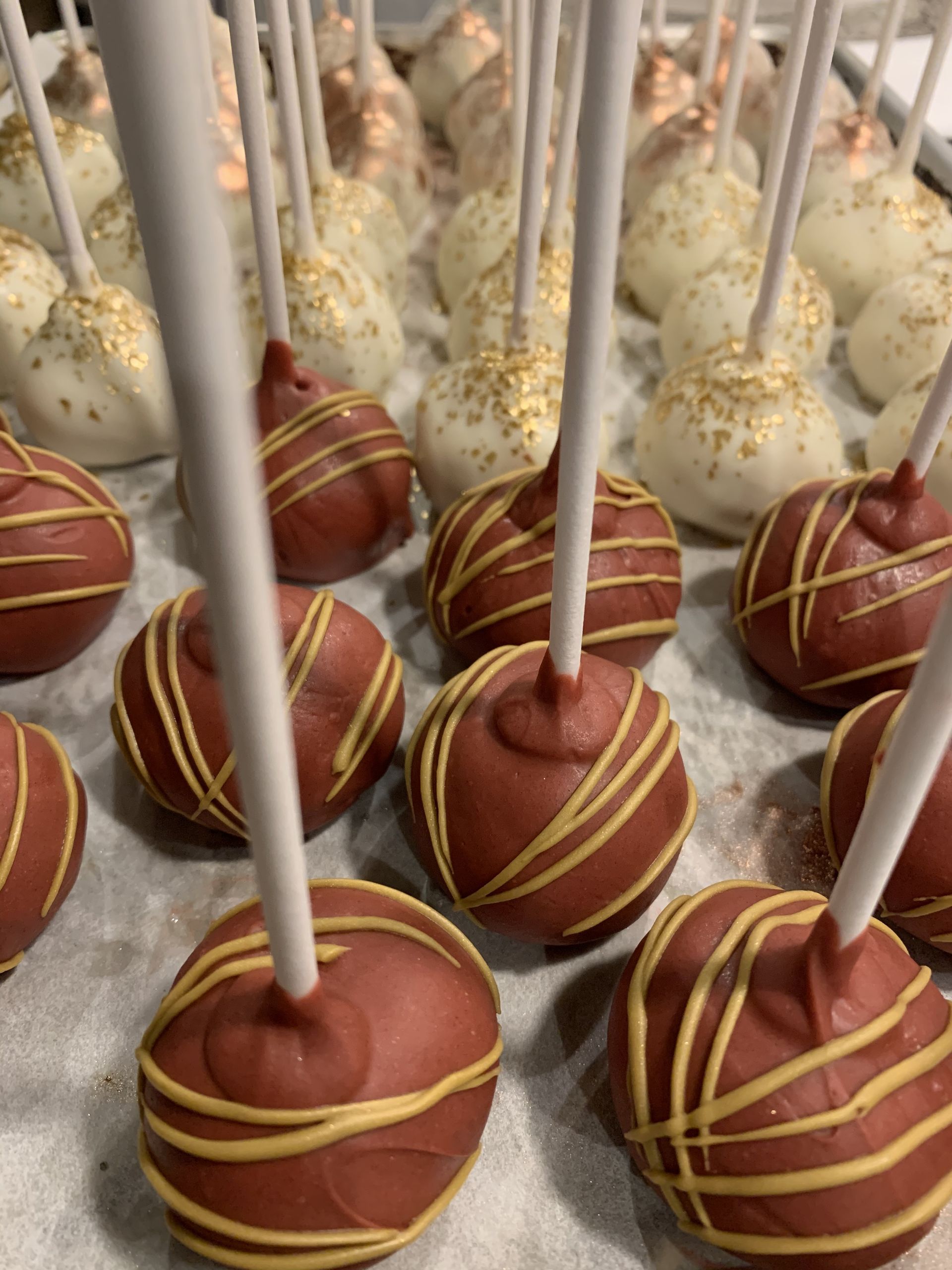 a bunch of chocolate cake pops on sticks on a table