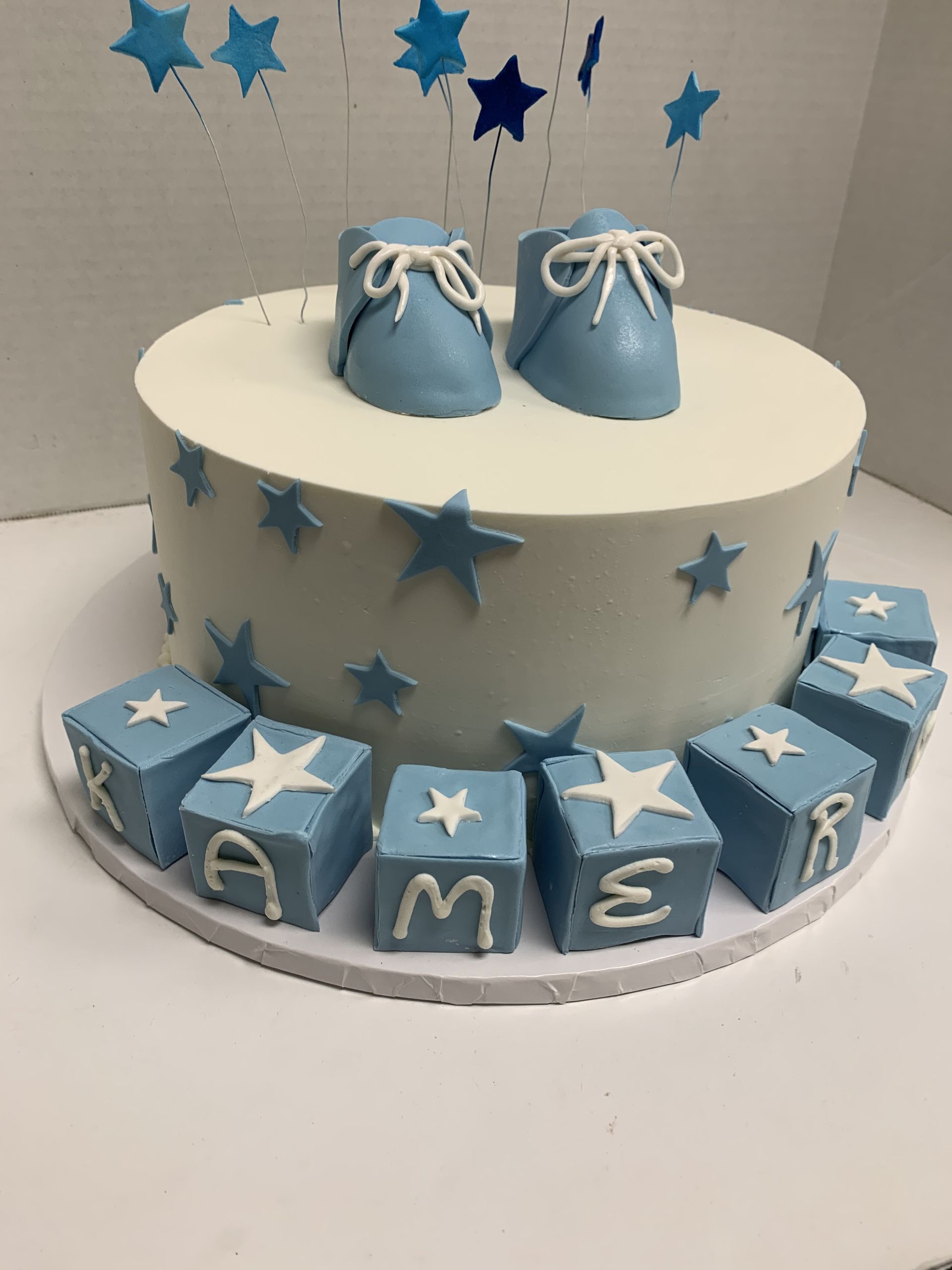 a baby shower cake with a pair of baby shoes on top