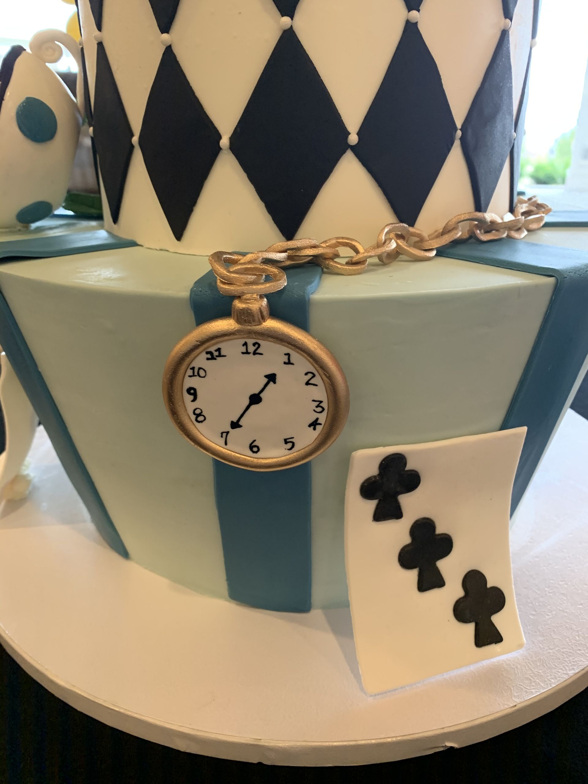 a cake with a pocket watch and playing cards on it