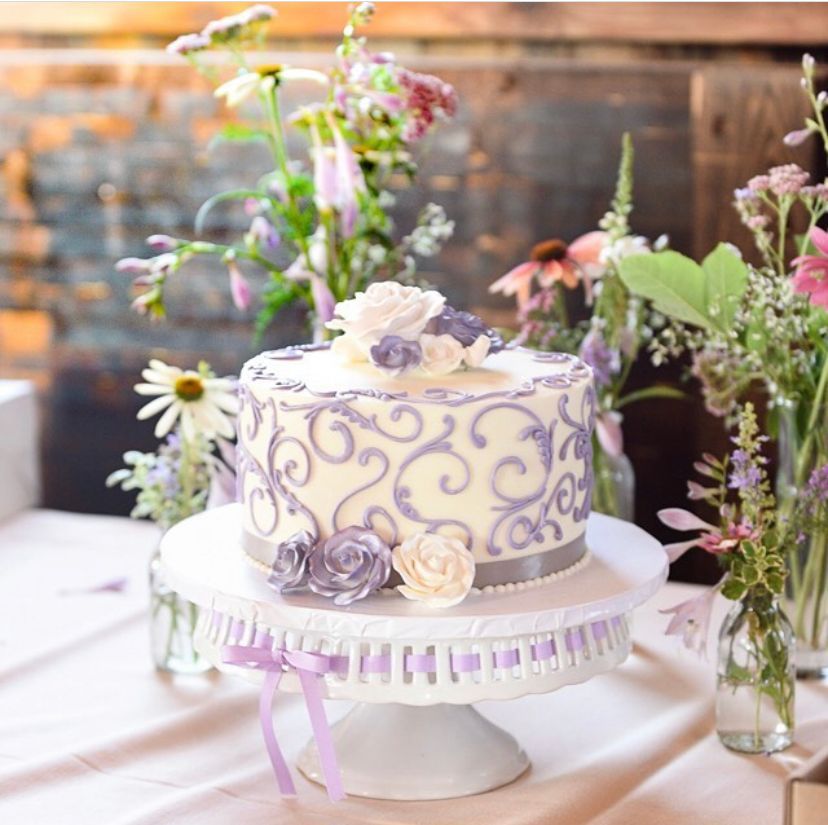 a white cake with purple swirls and flowers on it
