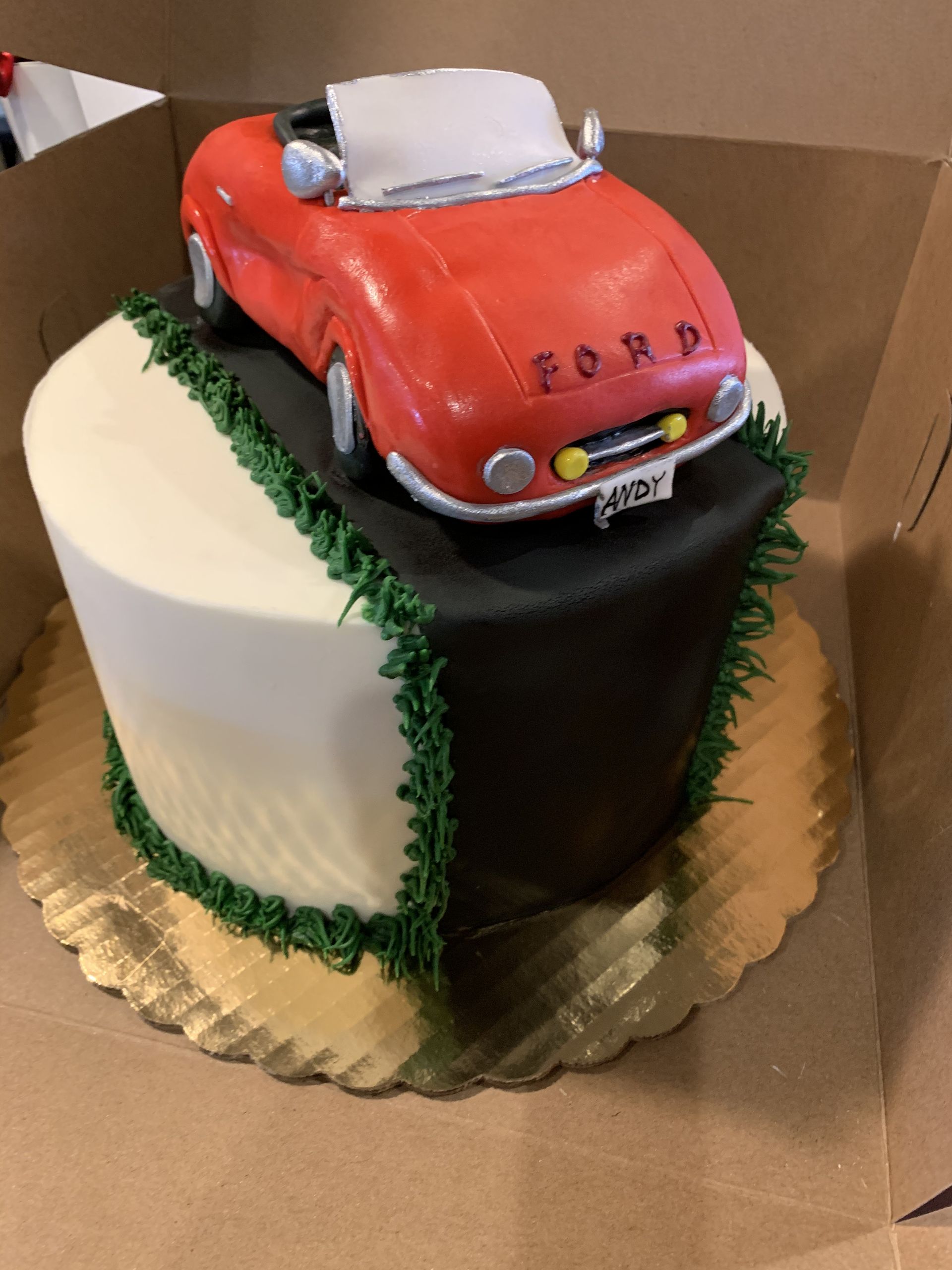 a cake with a red ford car on top of it