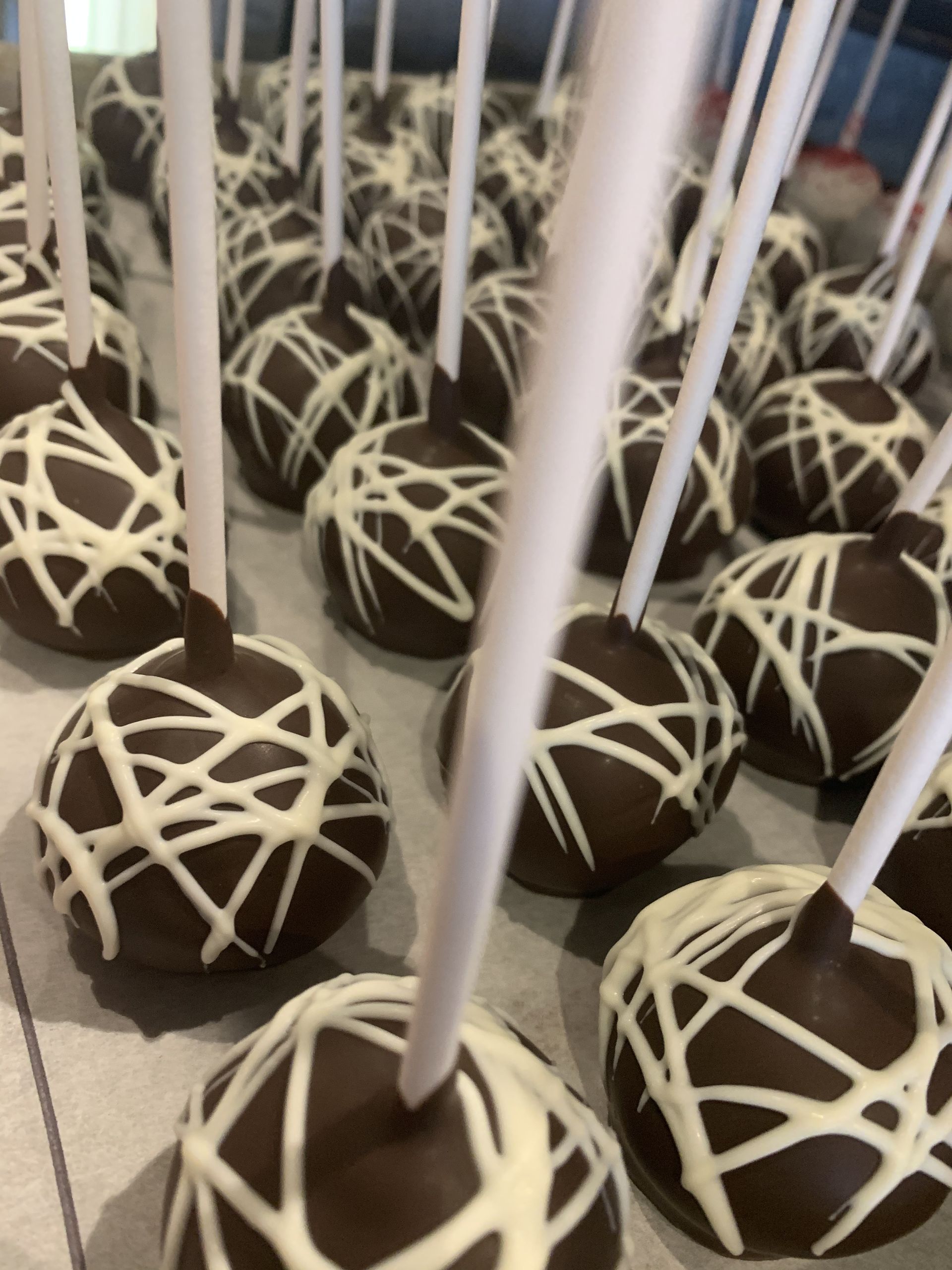 a bunch of chocolate cake pops with white frosting on them