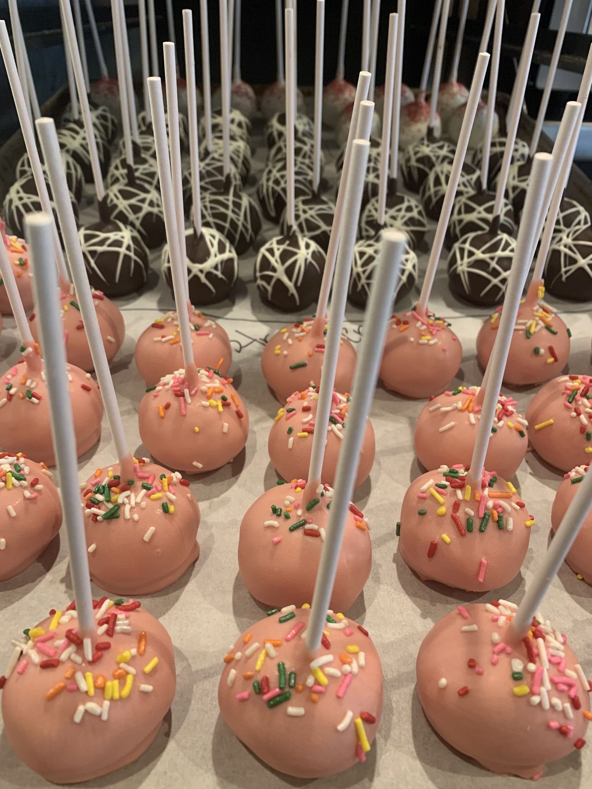 a bunch of pink cake pops with sprinkles on them