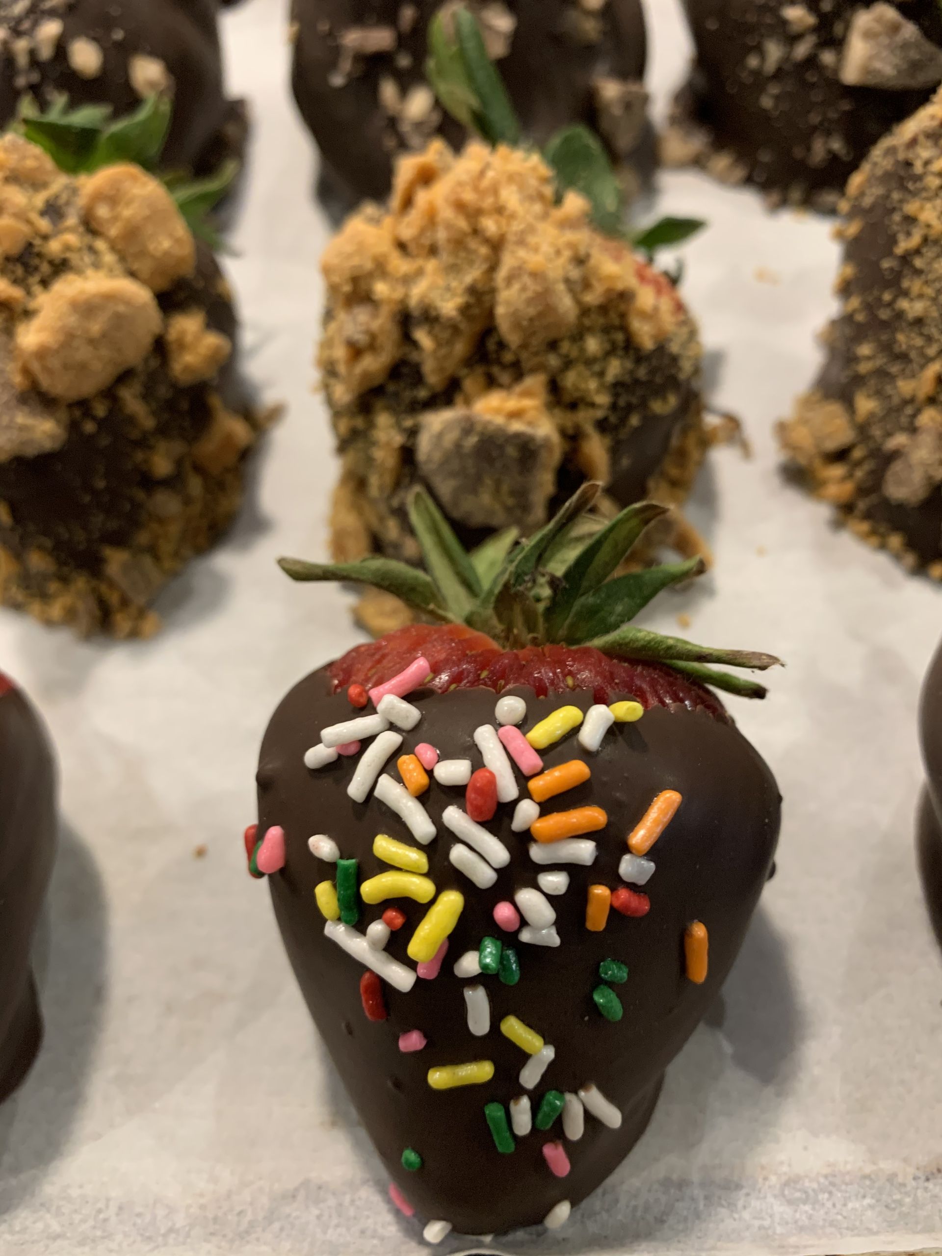 a chocolate covered strawberry with sprinkles on it