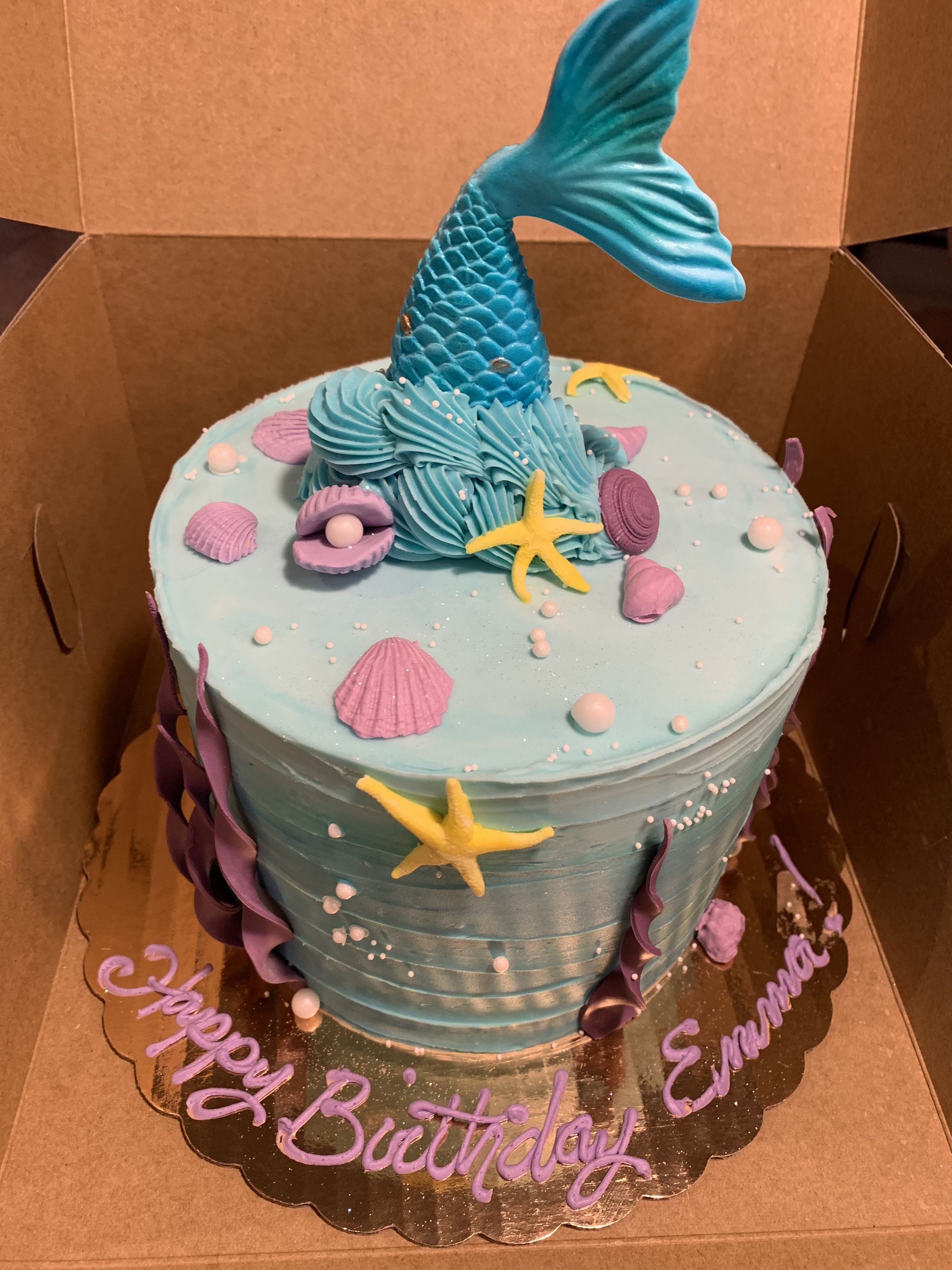 a birthday cake with a mermaid tail on top