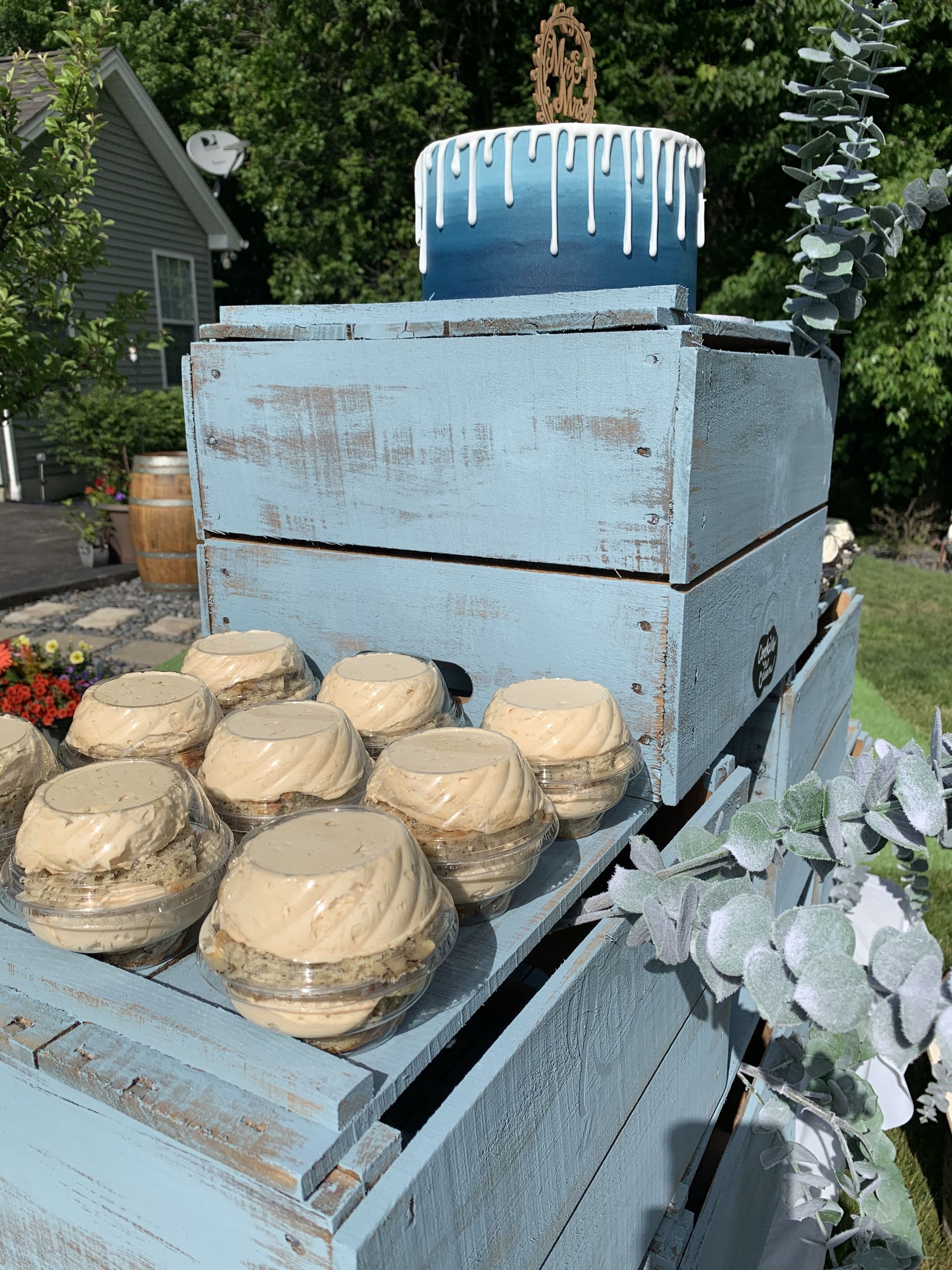 a blue crate filled with cupcakes and a cake on top of it .