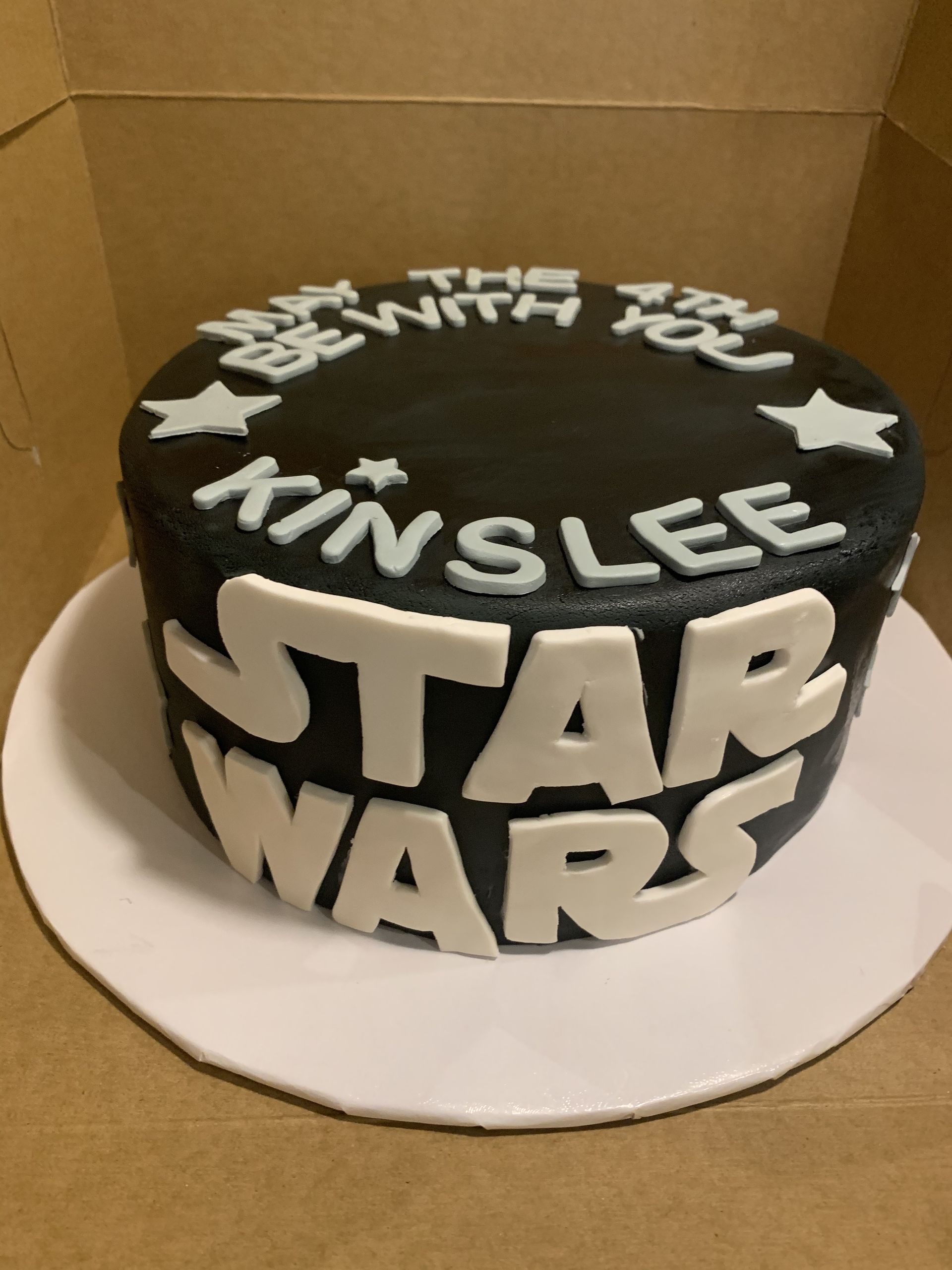 a black and white star wars cake with the name kinslee on it