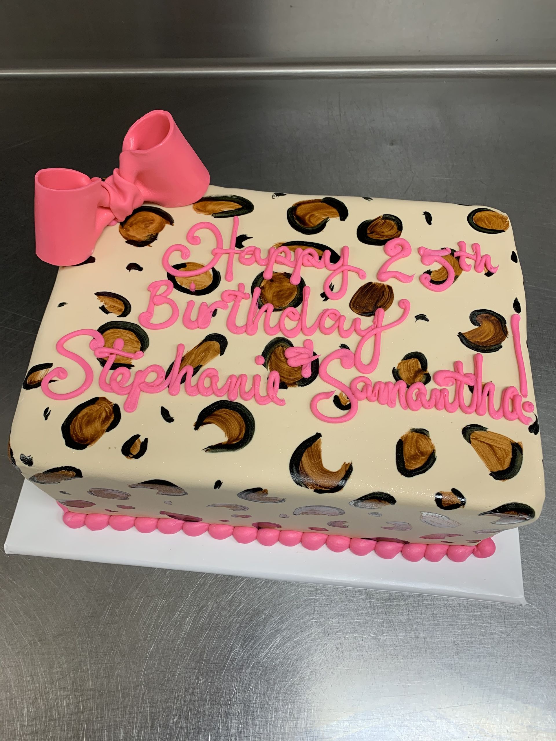 a leopard print birthday cake with a pink bow