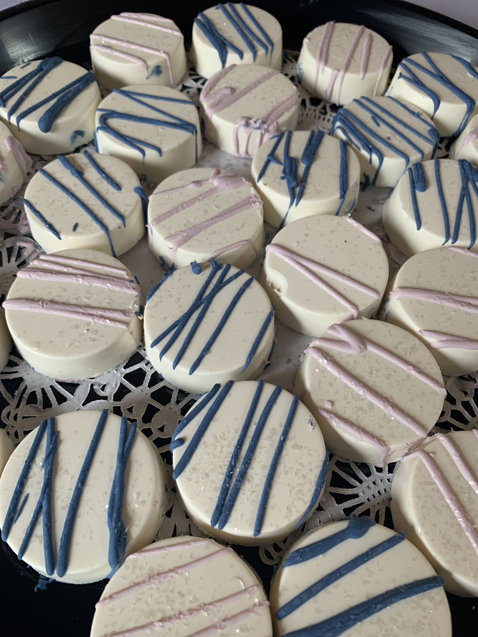 a plate of cookies with blue and pink stripes on them