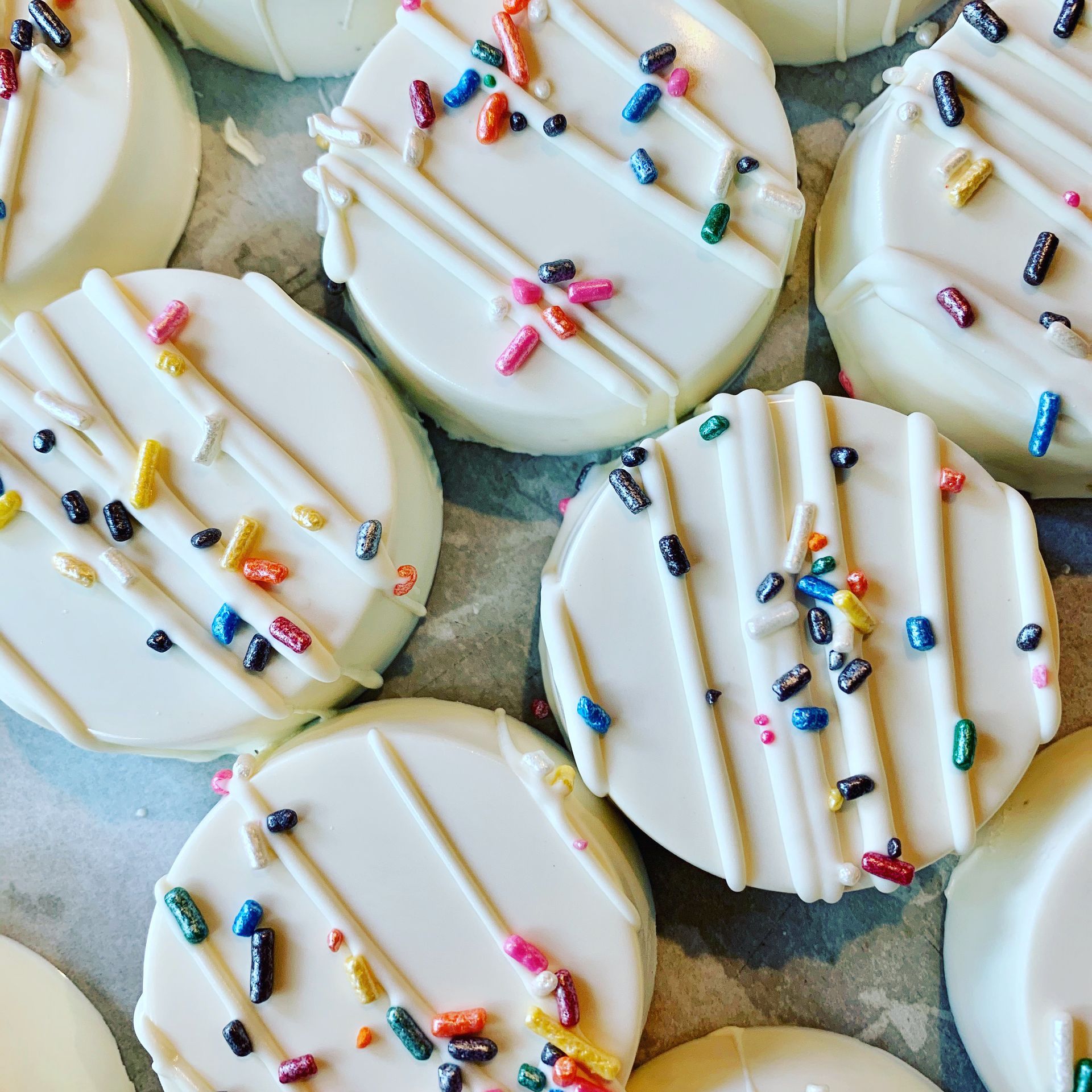 a bunch of white cookies with sprinkles on them